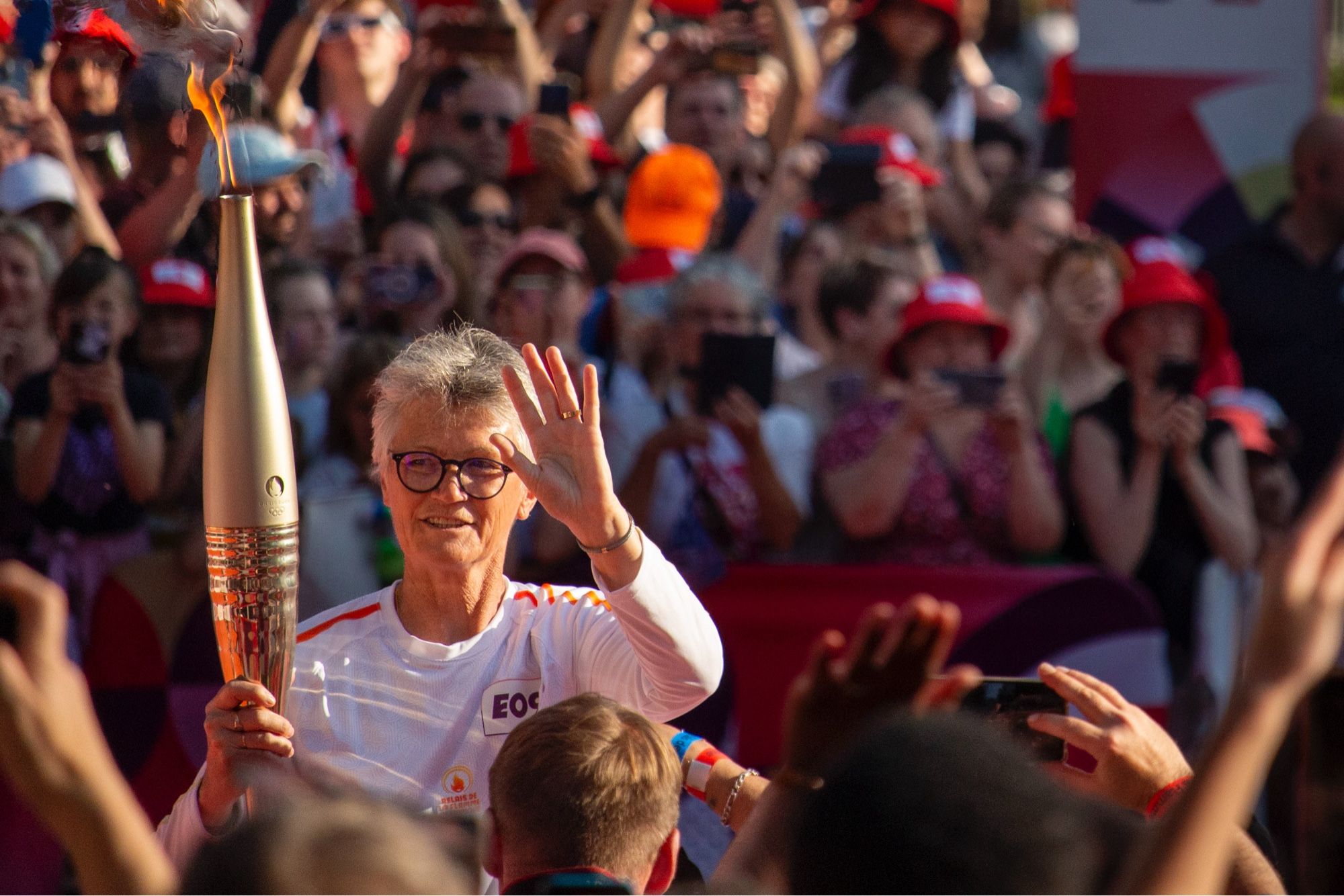 Sophie Moressée-Pichot salue la foule avec la flamme olympique dans sa main droite