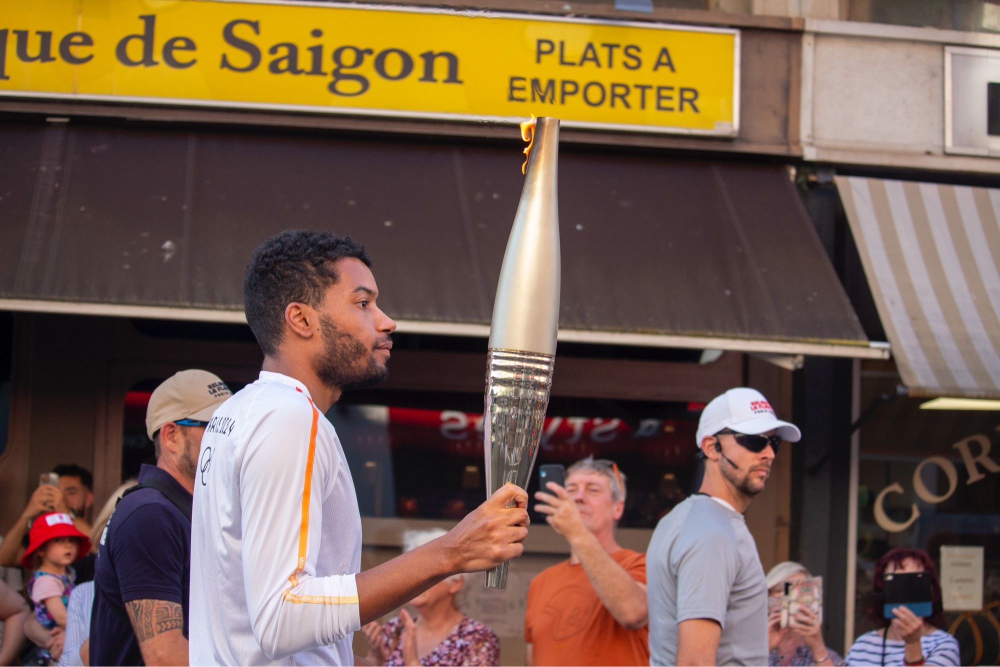 Porteur de la flamme olympique en environnement urbain, vu de côté