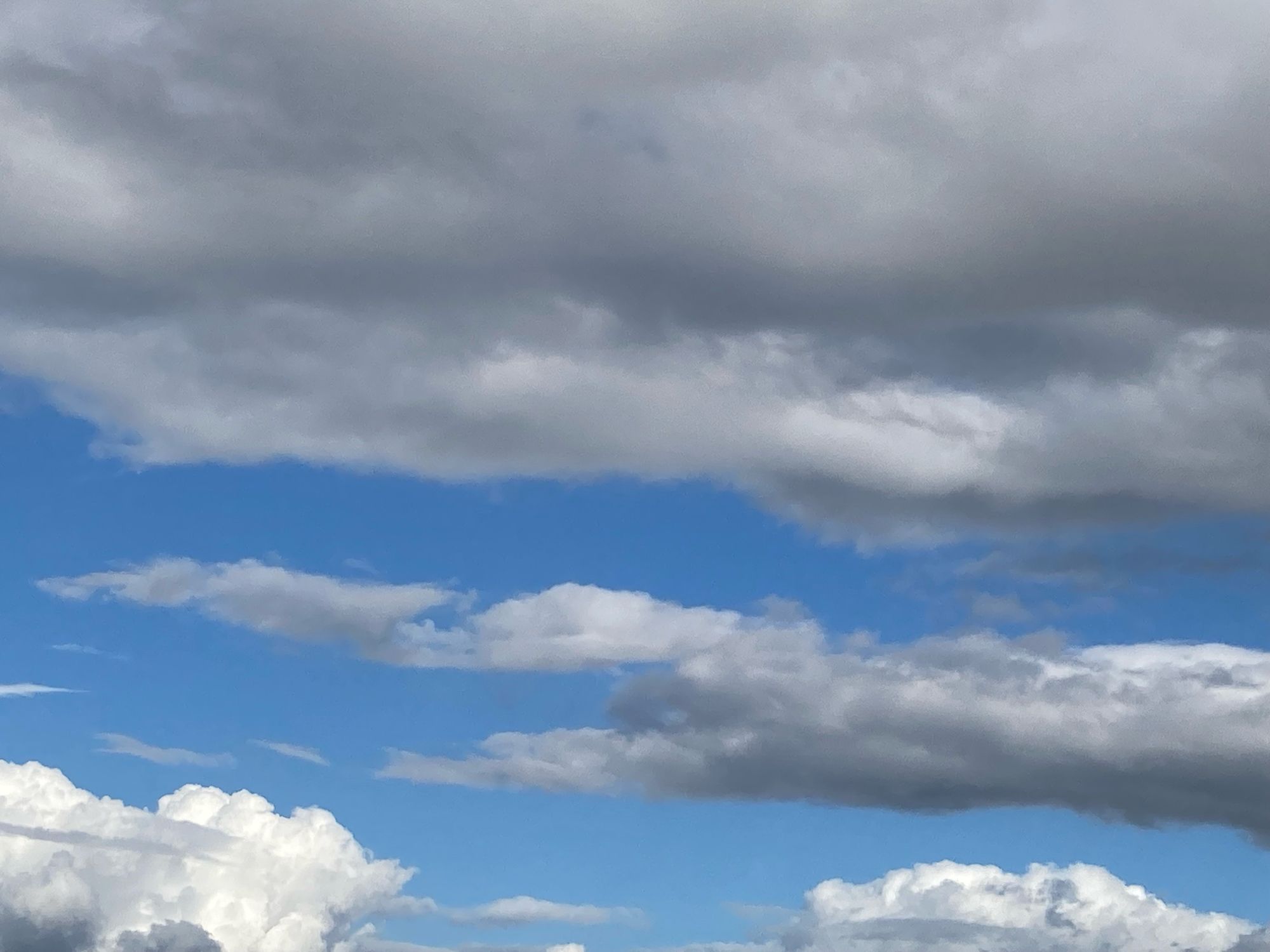 Blauer Himmel mit schweren Regenwolken.