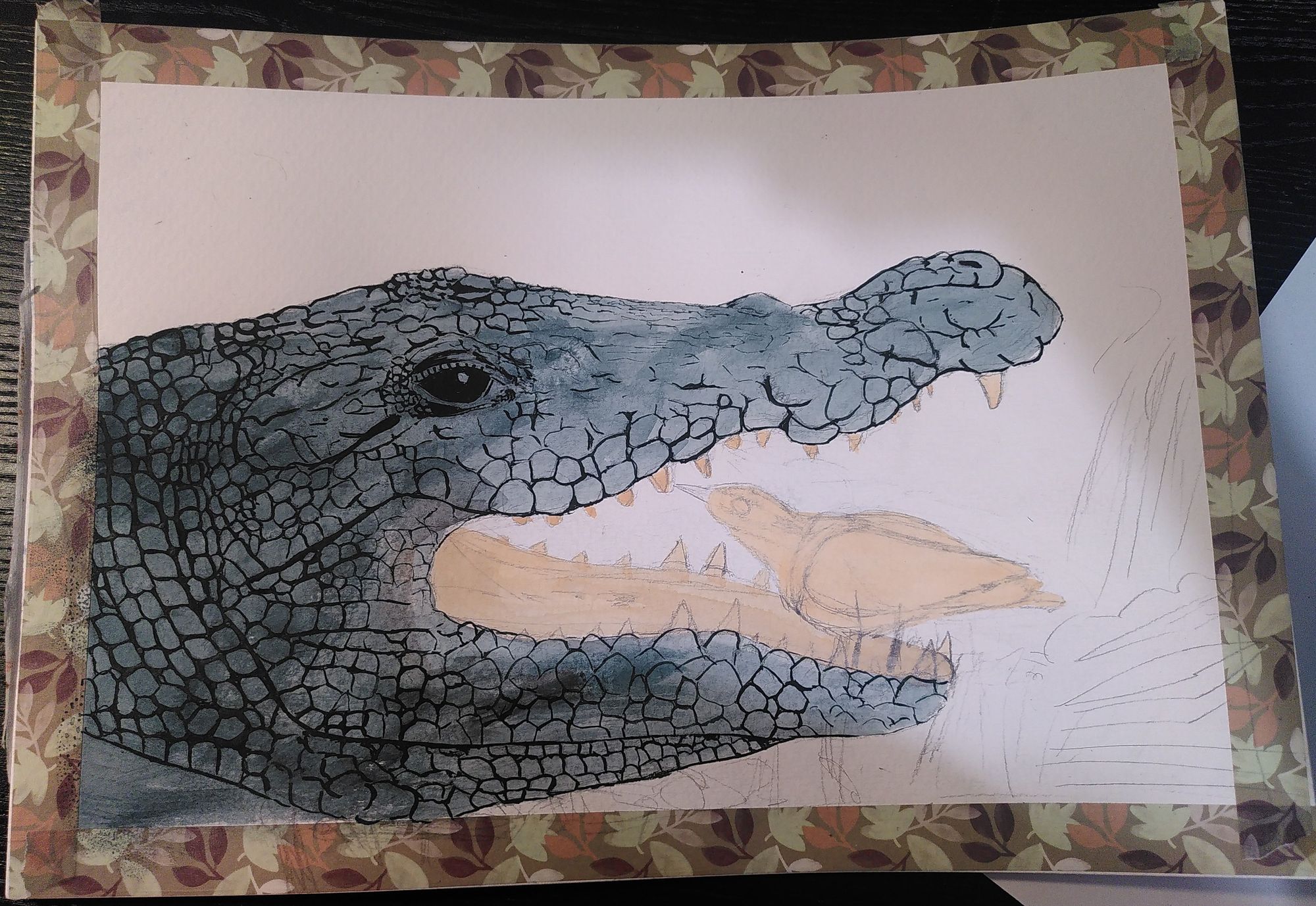 WIP gouache painting. There is a head of a crocodile, it has its mouth wide open. Inside is  bird picking the teeth of the crocodile. Note that in reality there is no proof this actually happens.
The crocodile is painted in a blueish green, with the outlines of the scales and the eye in a dark shade. The inside of the mouth and the bird are in a fleshy pink. There is no background yet except a few loose pencil strokes. 