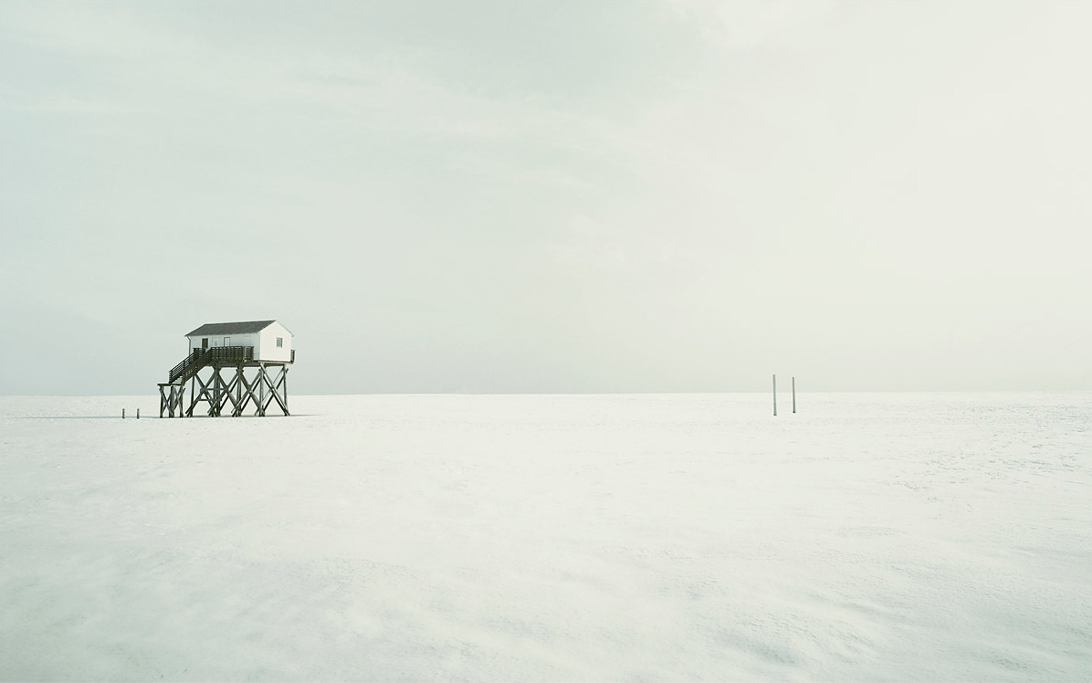 Une maison sur pilotis isolée sur un lac gelé