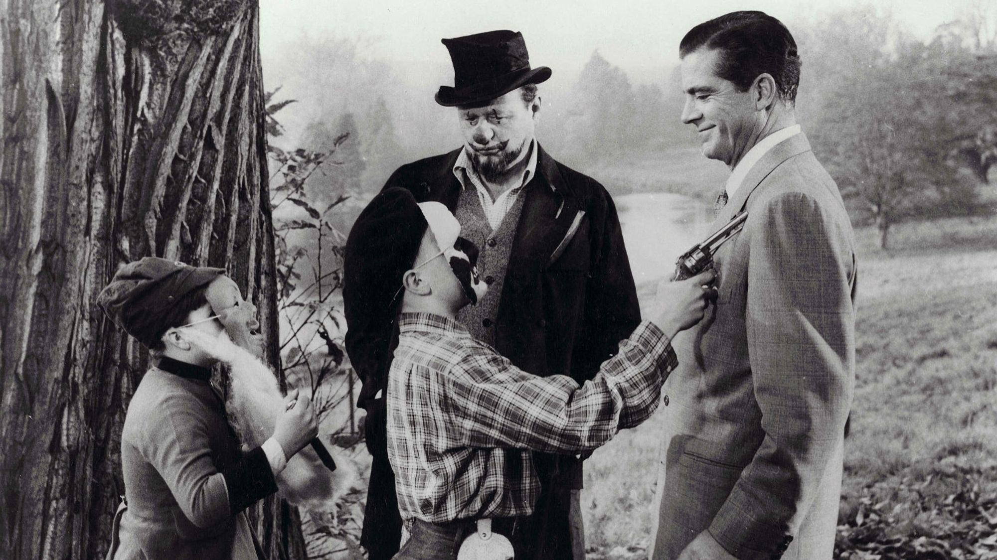 Scene from the movie Night of the Demon,  Niall MacGinnis and Dana Andrews with two children who are disguised in Fancy Dress at a garden party