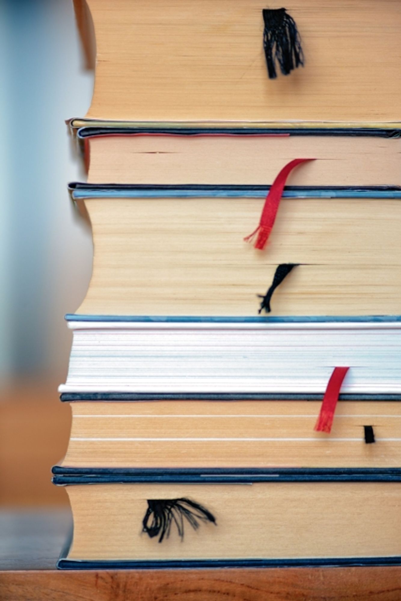 A stack of books with the silk bookmark ribbons sticking out.