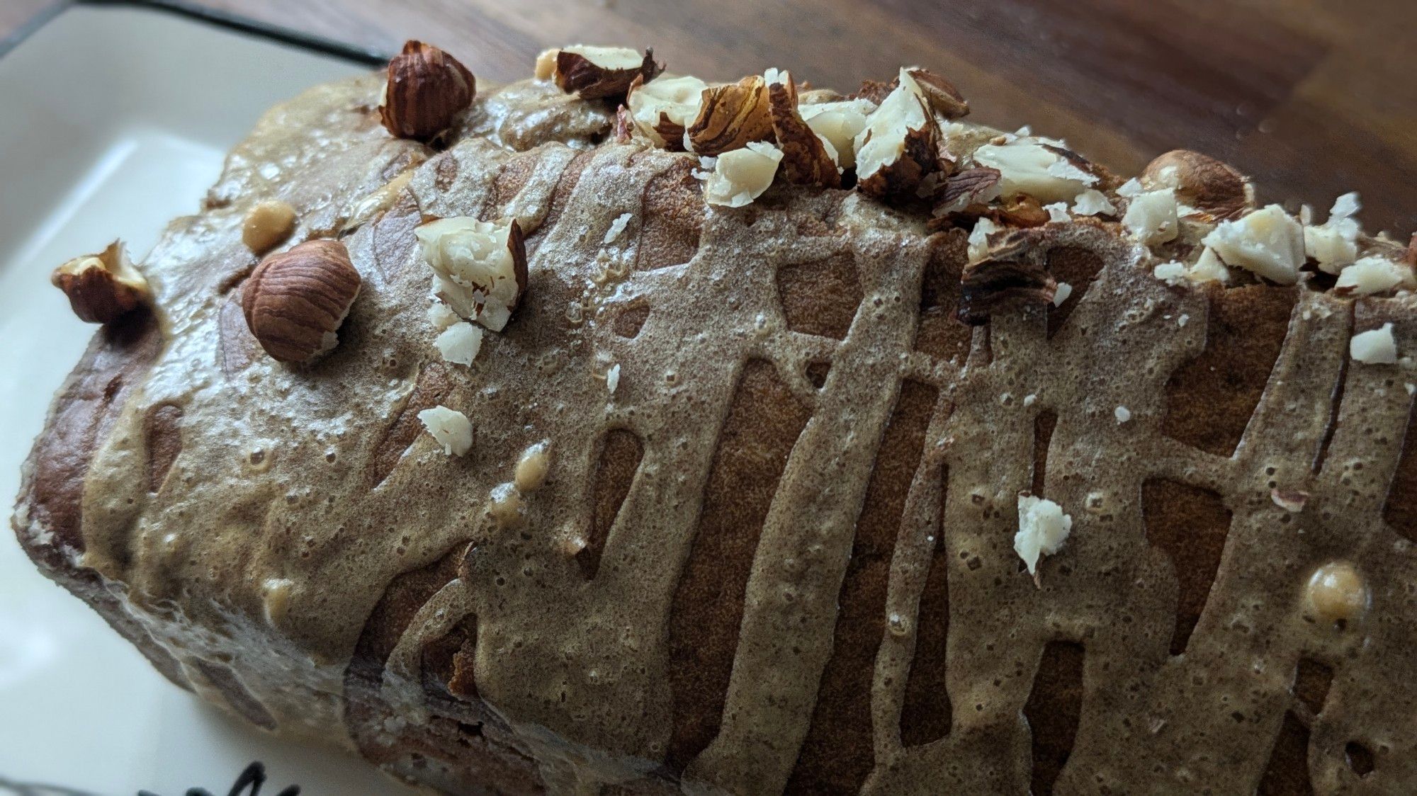 Cake avec gros plan sur le glaçage et les noisettes concassées.