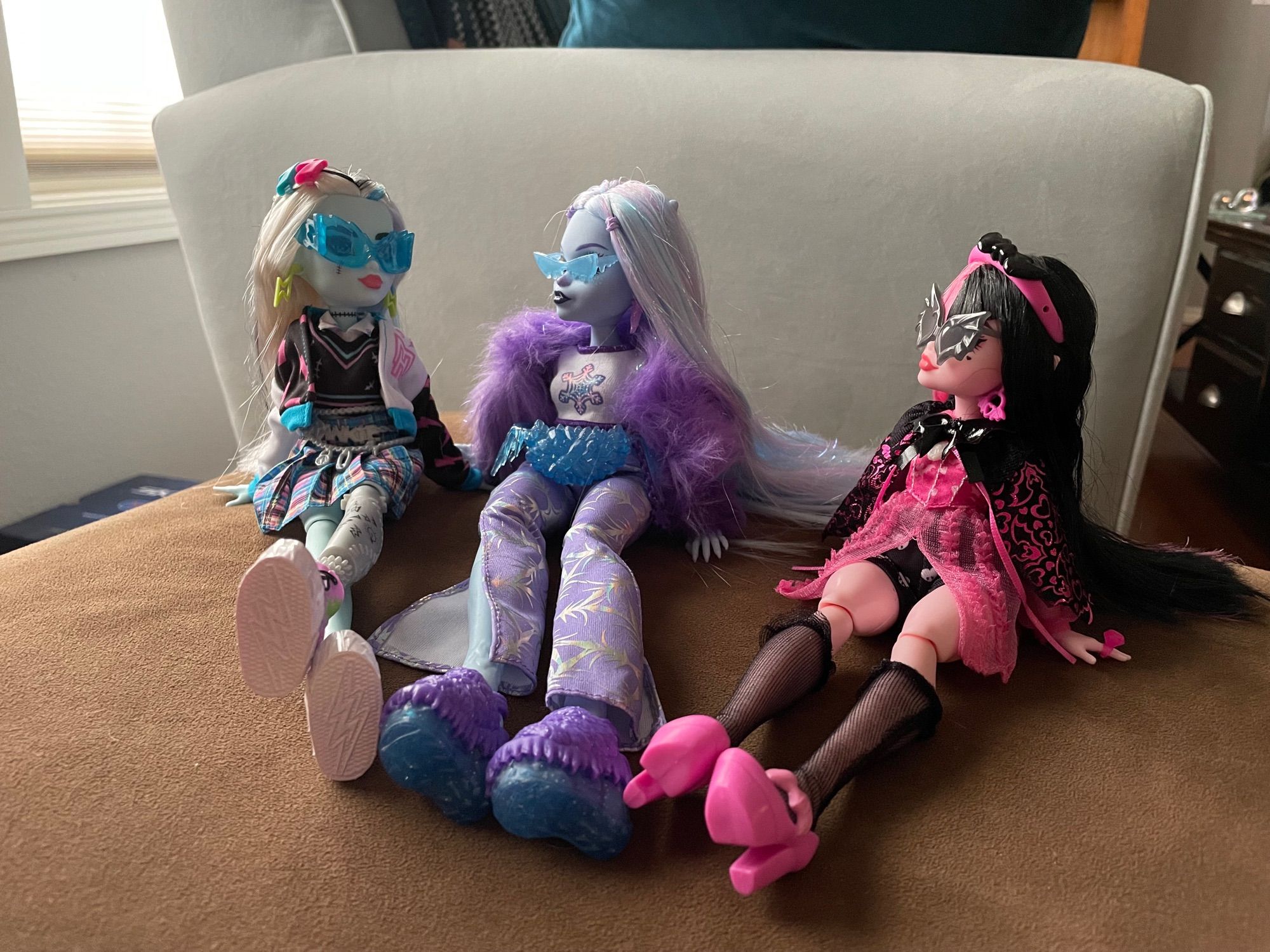 Frankie, Abbey, and Draculara G3 sit side by side, leaning on their hands. All wear sunglasses and are tuned toward each other as though talking