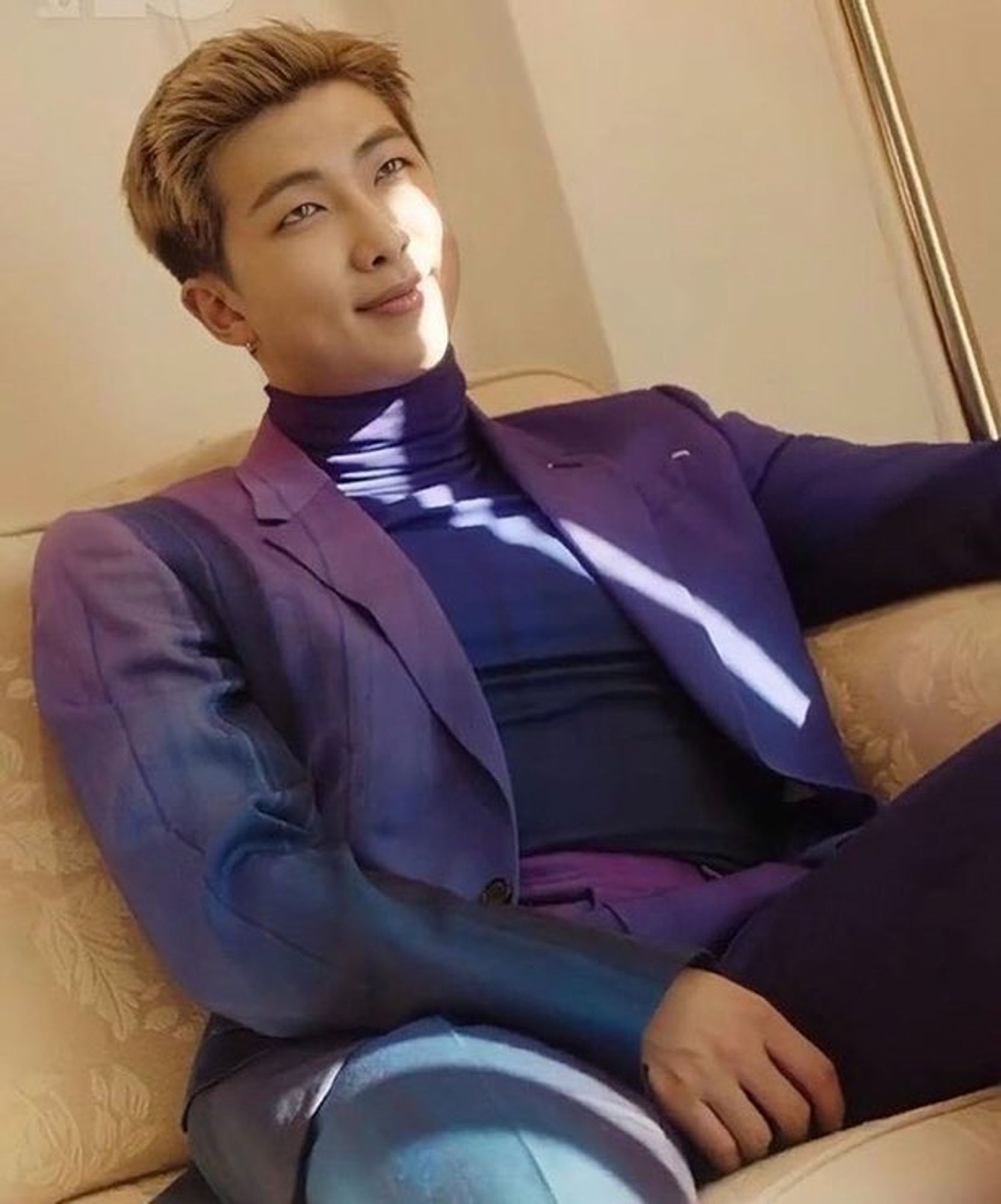 Blonde Joon in gradient Blue/Navy/Purple sitting in a chair with photo being taken from a low angle facing upwards