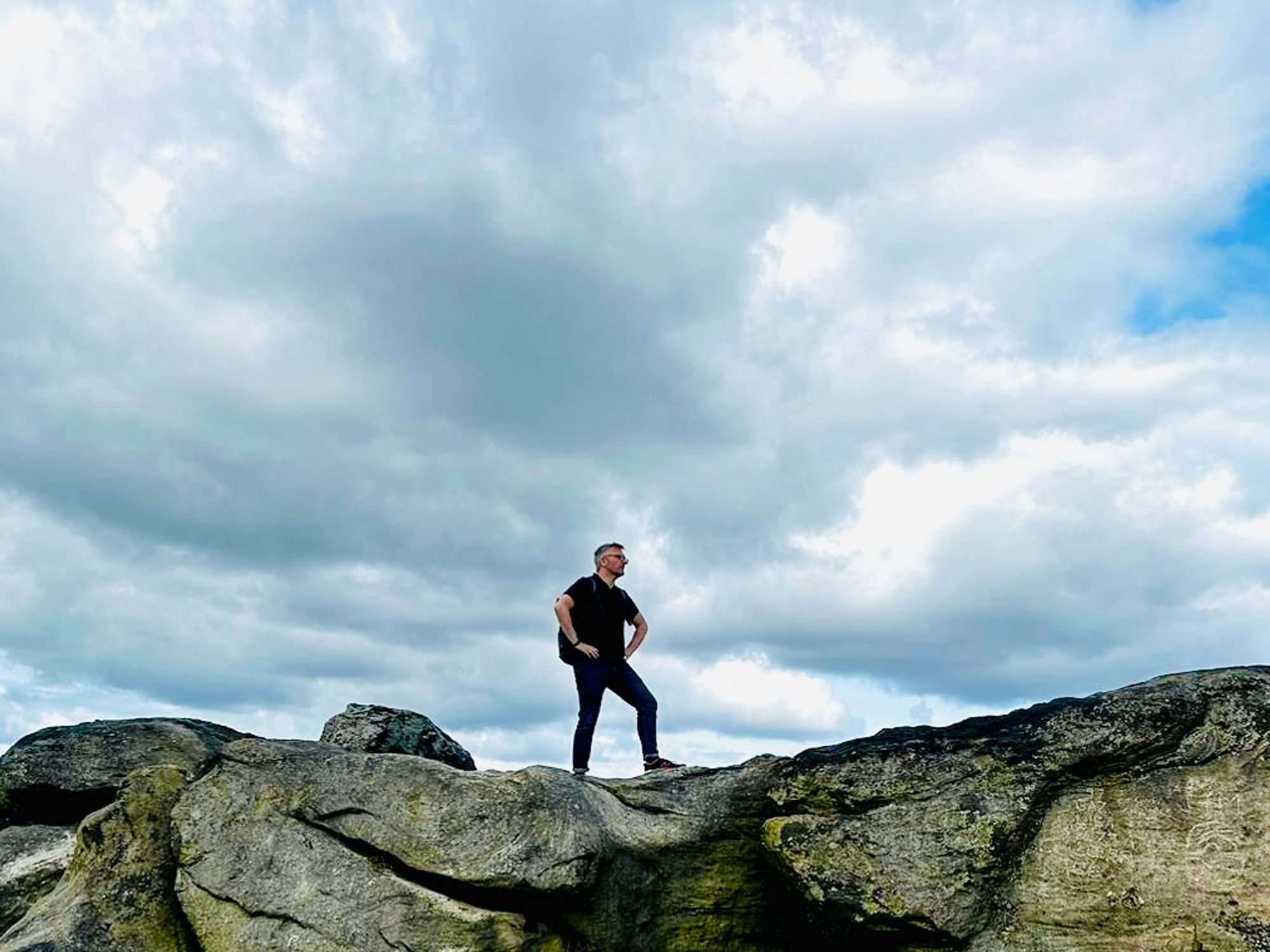 Photo of me standing on a rock with a dramatic cloudy background