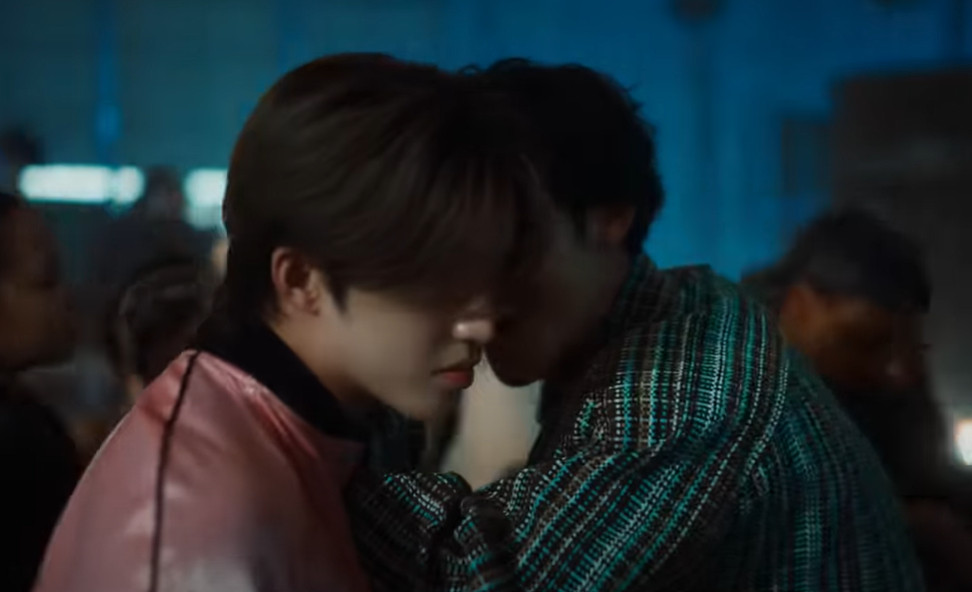 screenshot from the 'eyes on you' mv by kpop boy group seventeen, mingyu leaning in to whisper in seungcheol's (scoups) ear