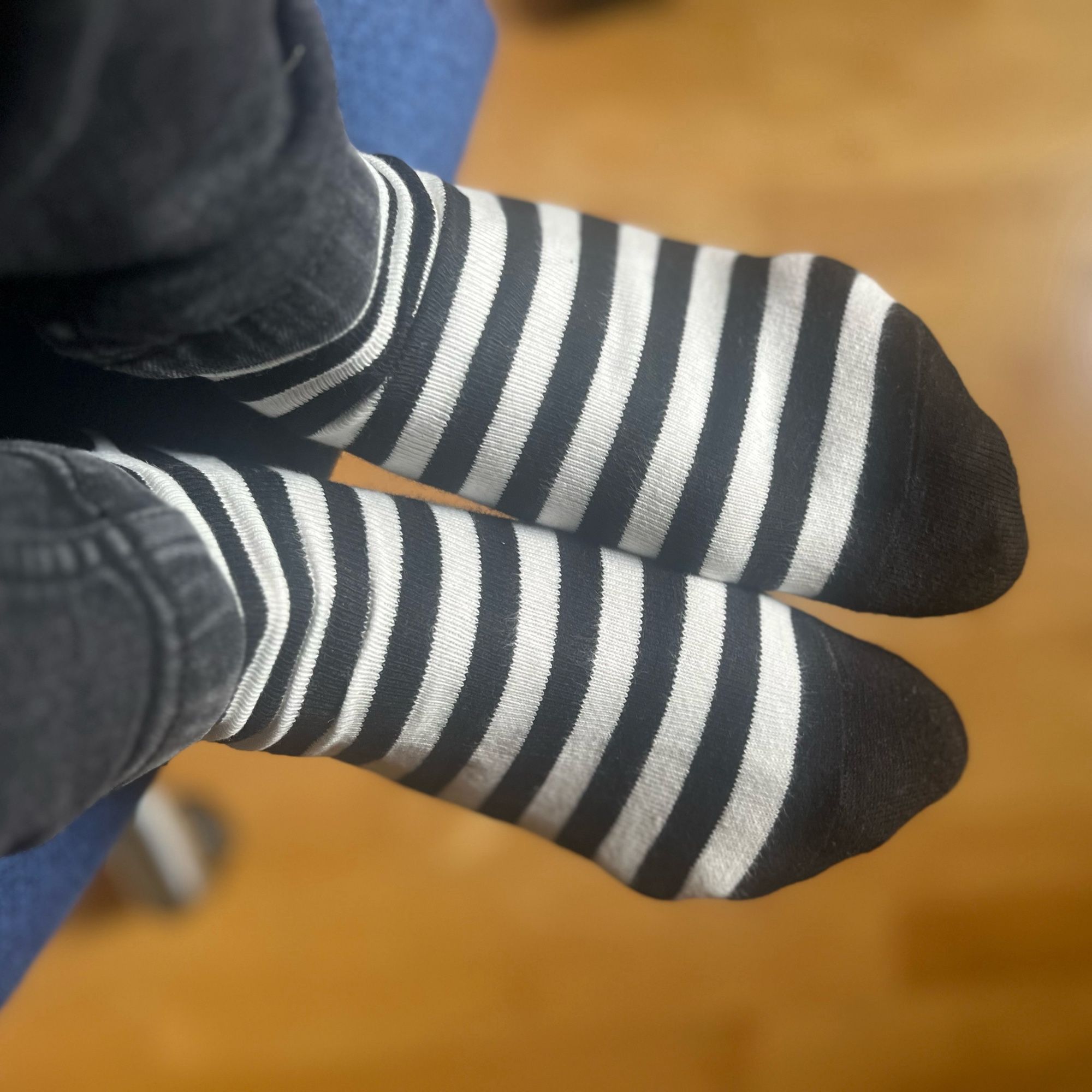 Two feet wearing a pair of black and white striped socks