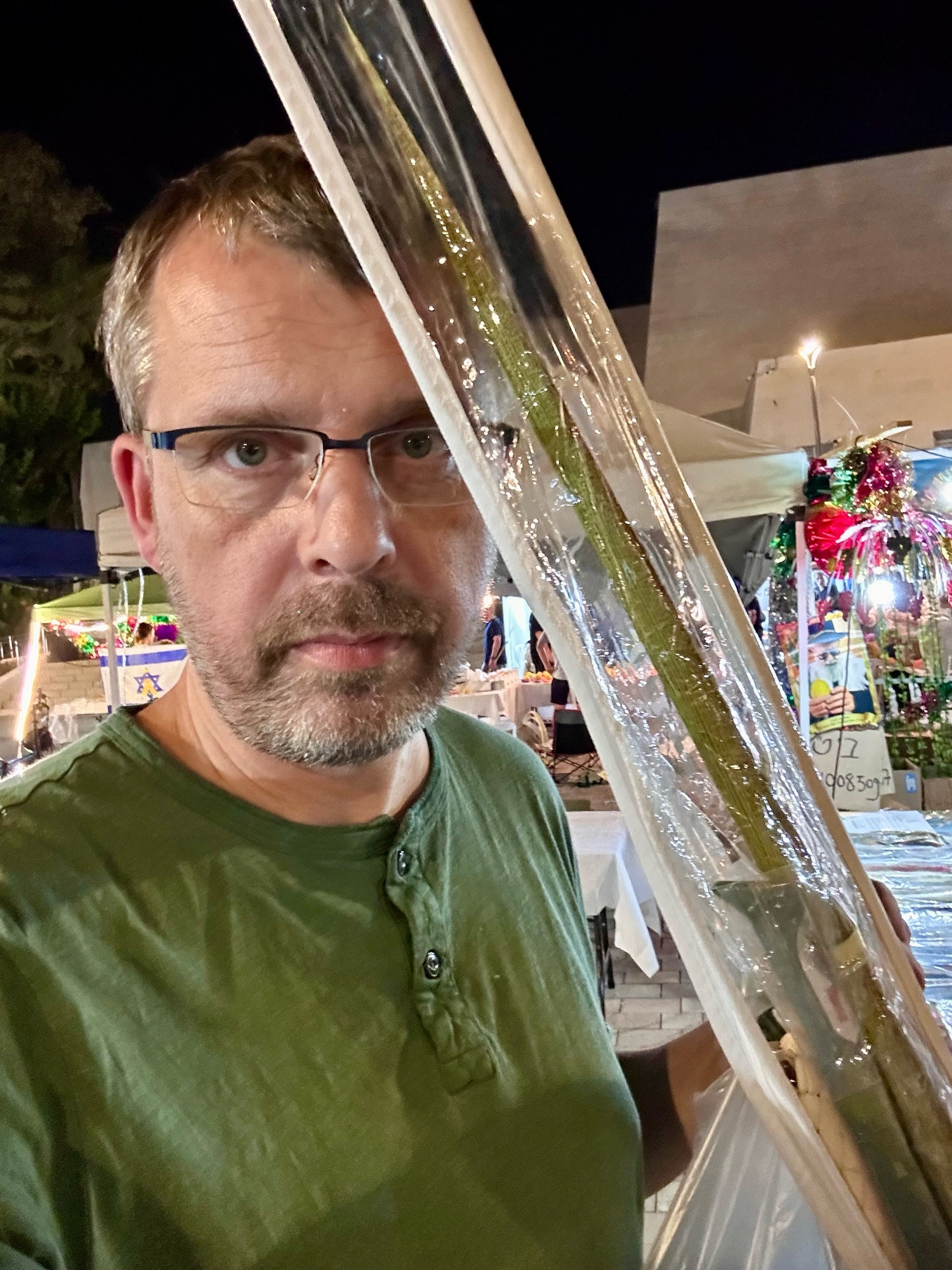 Selfie auf dem Markt. In der Hand eine längliche Verpackung mit Arbat Haminim. 