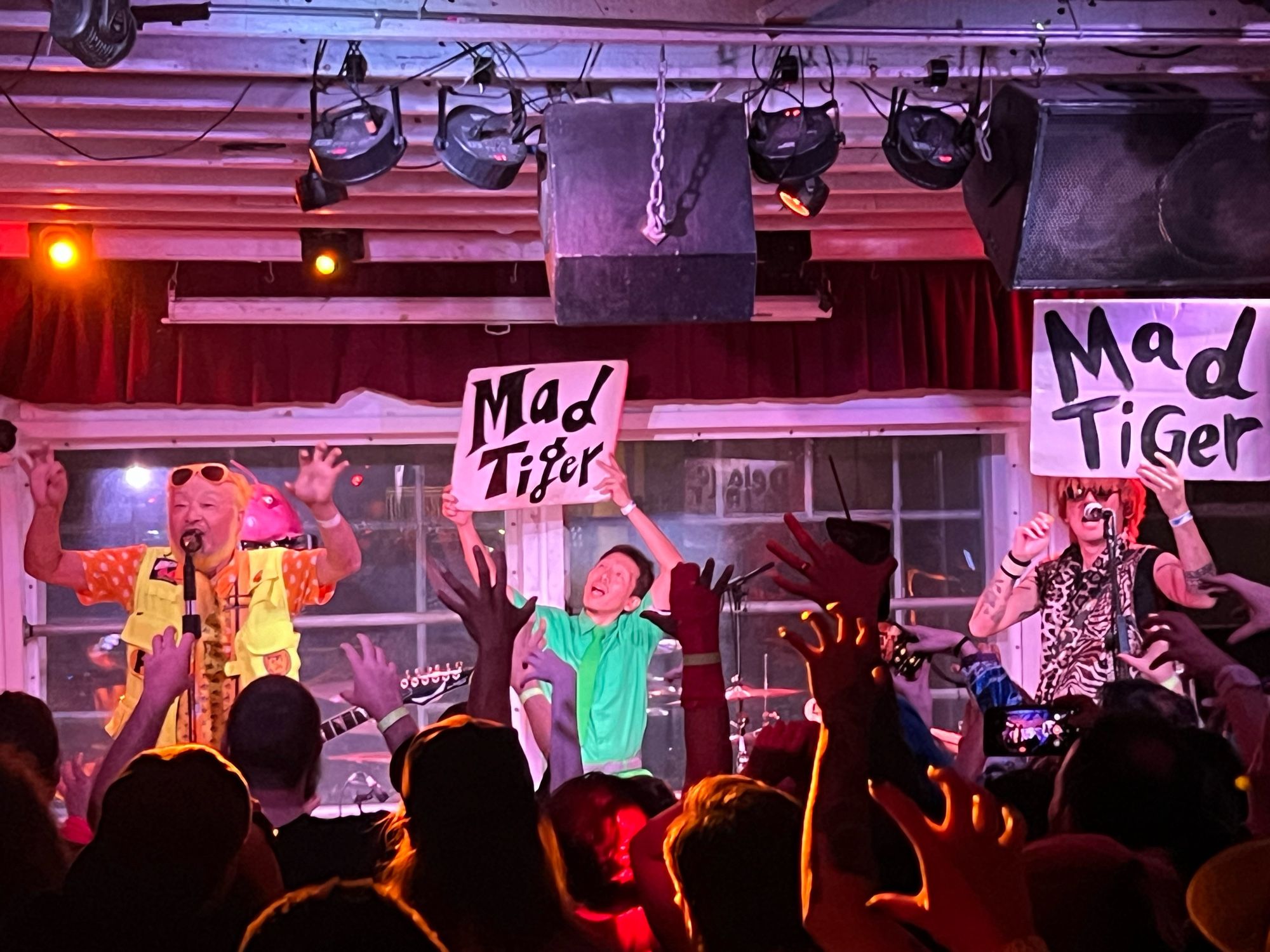 Peelander-Z performs Mad Tiger. The band holds up signs with the song's title while Peelander Yellow and the audience make clawing hand gestures