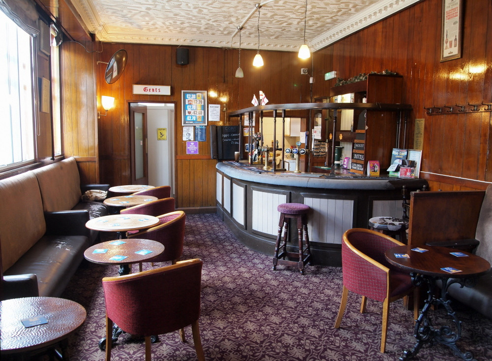 Lounge Bar circa. 2009, with original bar counter and bar back, bench seating, Gents sign and coat hangers.