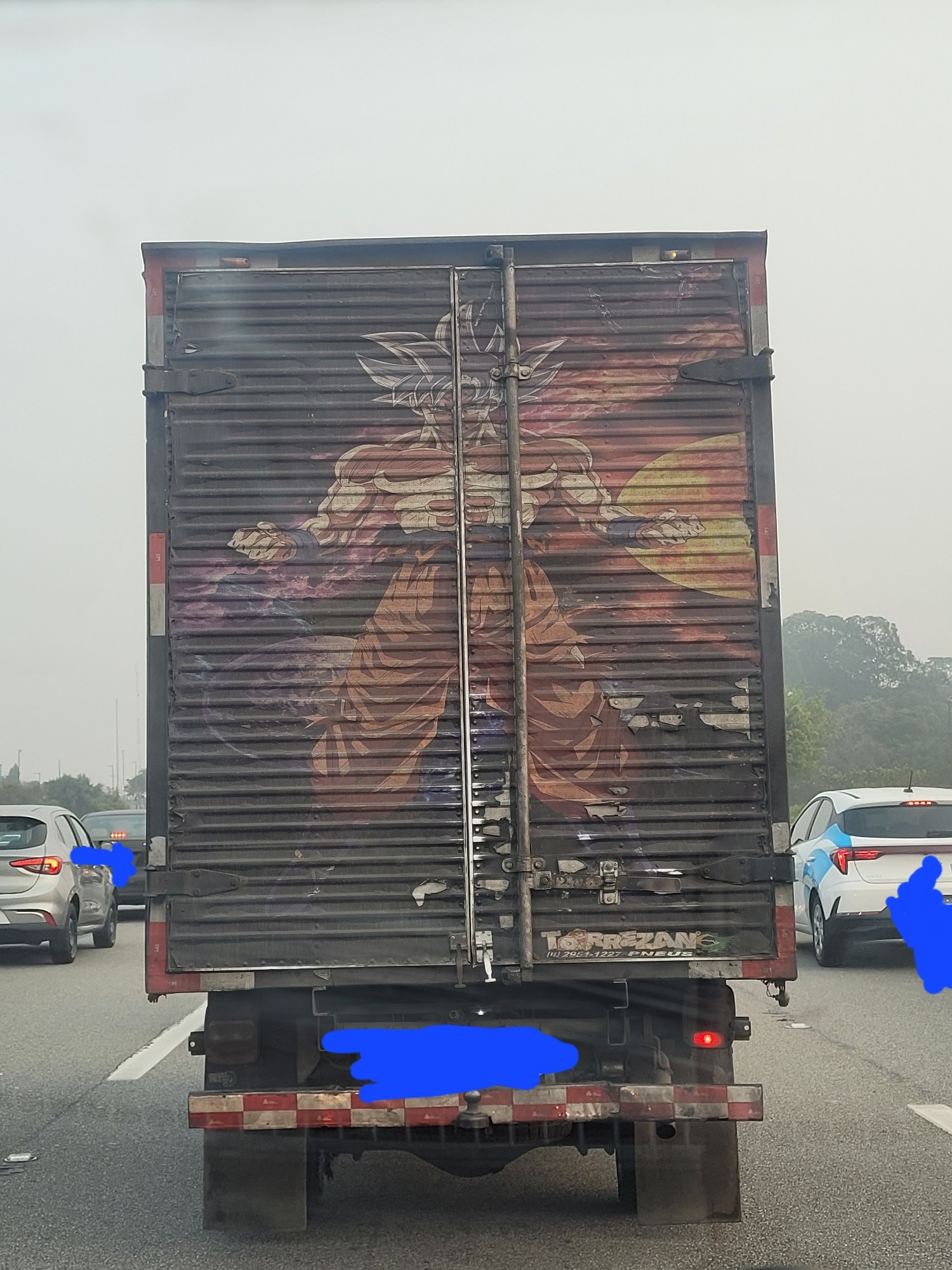 A truck with a painting of Ultra Instinct Goku in the back.