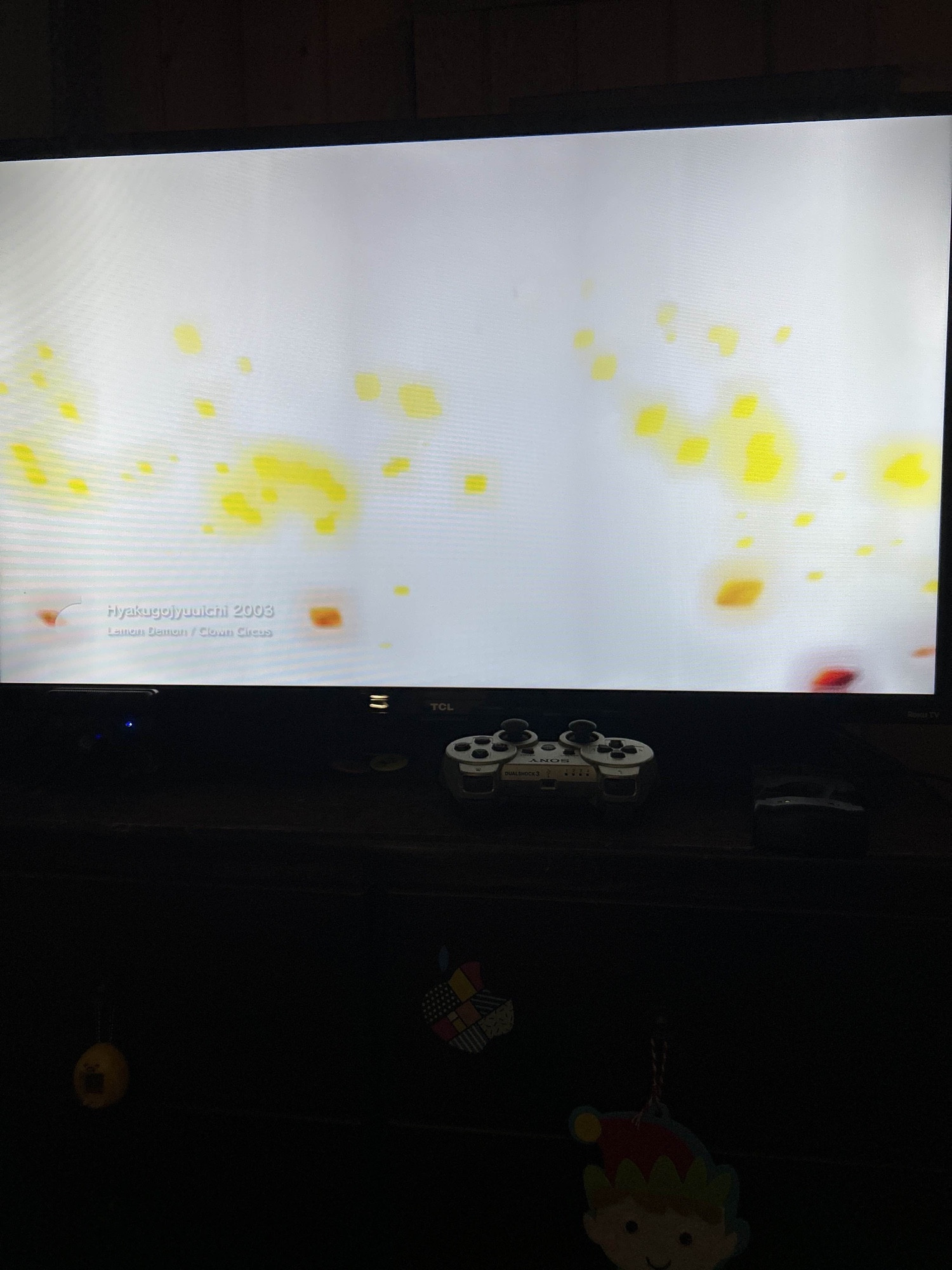 my ps3 (slim) displaying a visualiser, a grey ps3 controller can be seen in front of the tv