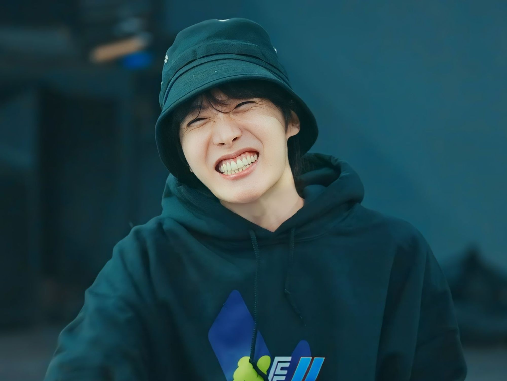 Hobi in a black hoodie and hat, with his famous heart-shaped smile that can fix all of my problems