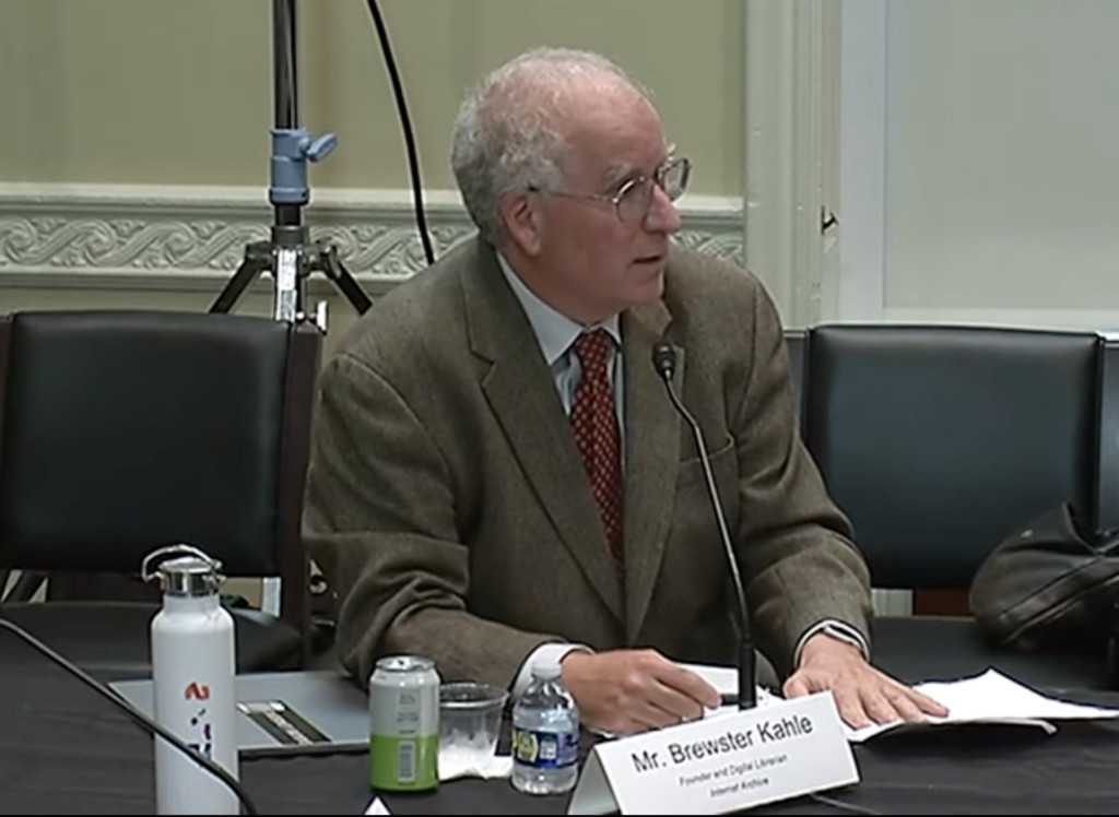 Brewster Kahle wears a brown jacket and dark red tie as he talks to the congressional round table.