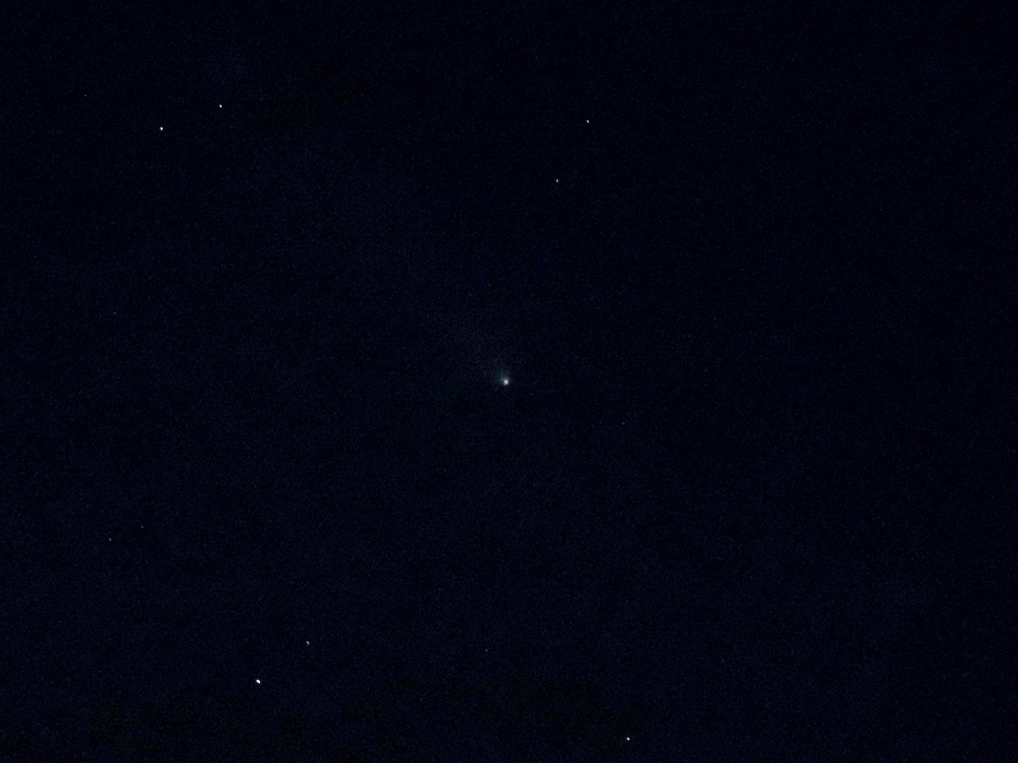 Comet Atlas. A very faint fuzzy blob with a hint of a tail to the top left.