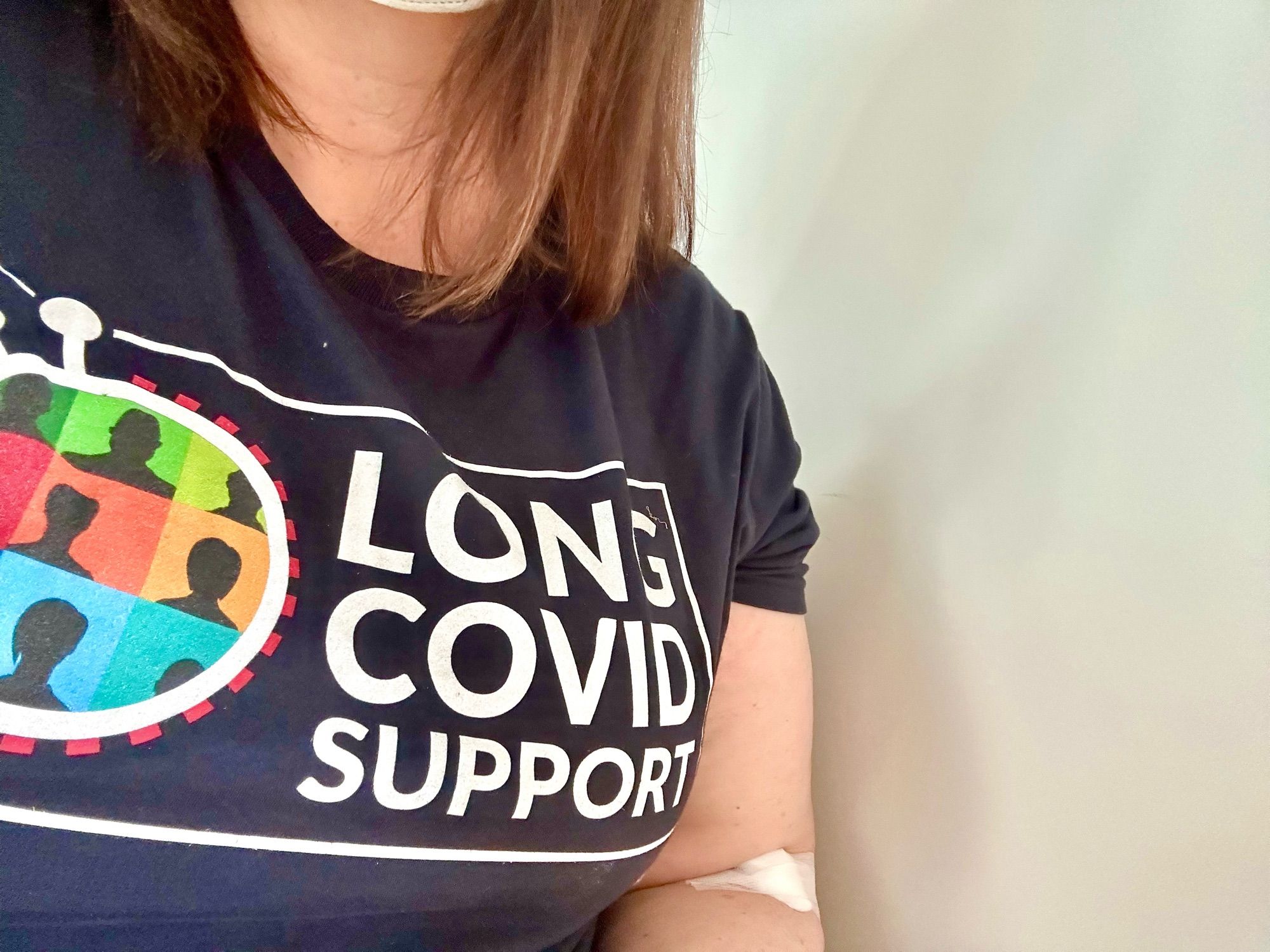 Photo showing the Long Covid Support logo on the dark blue t-shirt I’m wearing.