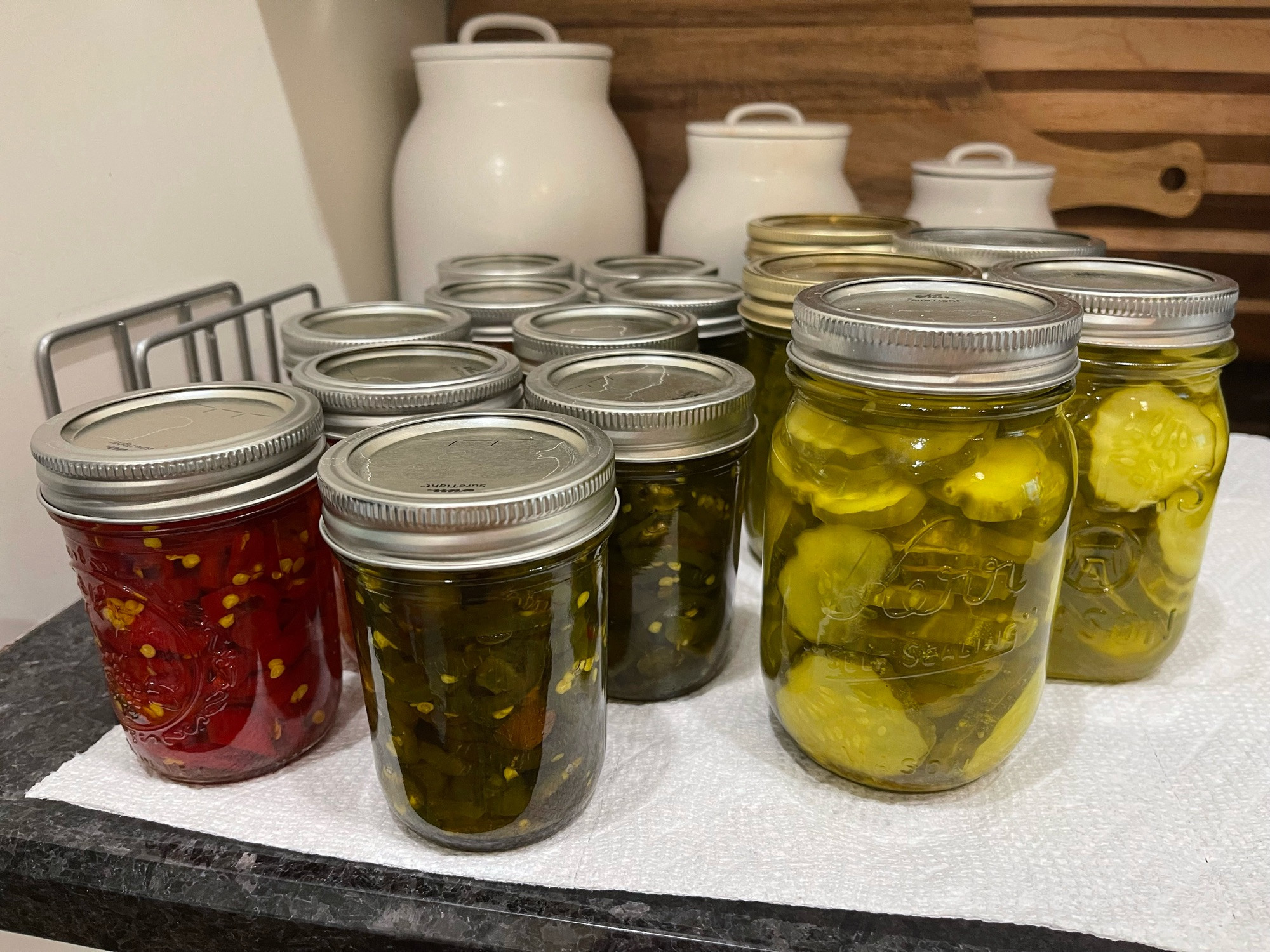 Canning jars filled with candied hot peppers and dill pickles