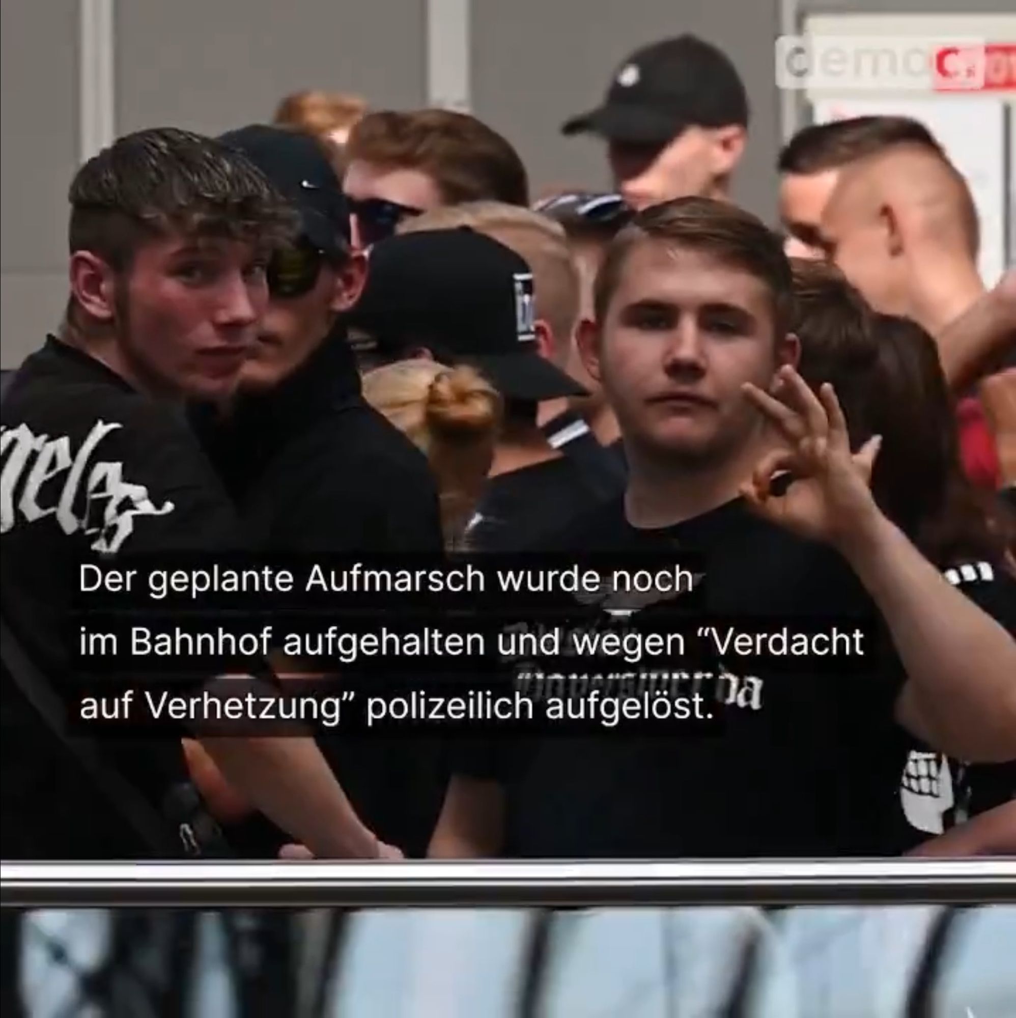 Schwarz gekleidete Rechtsradikale junge Männer in Kleidung mit Nazi-Symbolen zeigen das „White-Power-Symbol“.

Text im Bild: „Der geplante Aufmarsch wurde noch im Bahnhof aufgehalten und wegen "Verdacht auf Verhetzung" polizeilich aufgelöst.“