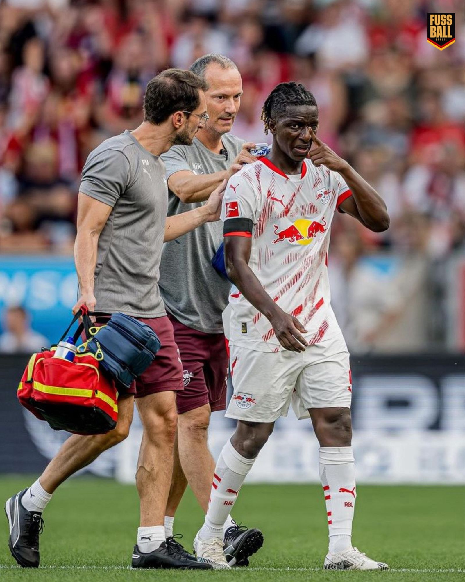 Amadou Haidara saindo da partida contra o Bayer Leverkusen junto dos médicos do RB Leipzig. 

(Photo via RB Leipzig).