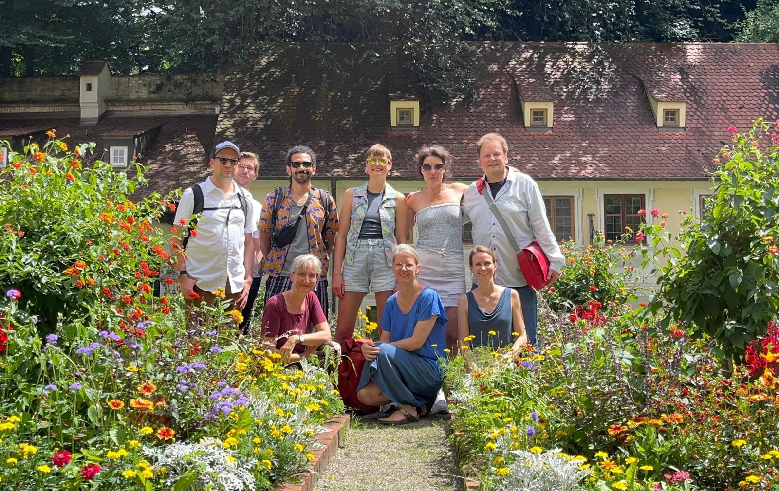 The team in a garden, in front of a house.