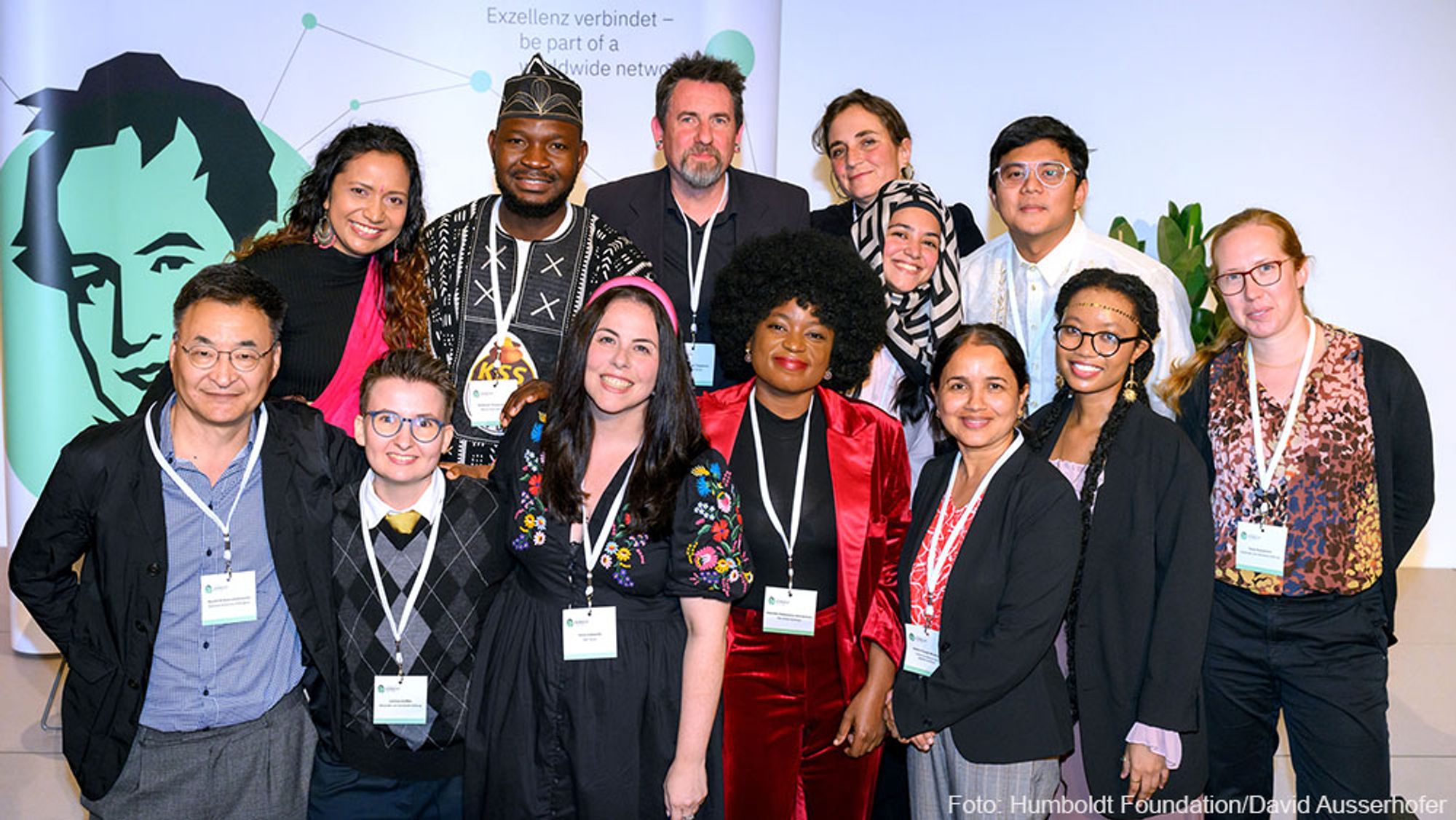 Group photo of 13 people looking into the camera and laughing. They are the participants of the Humboldt Residency Programme.