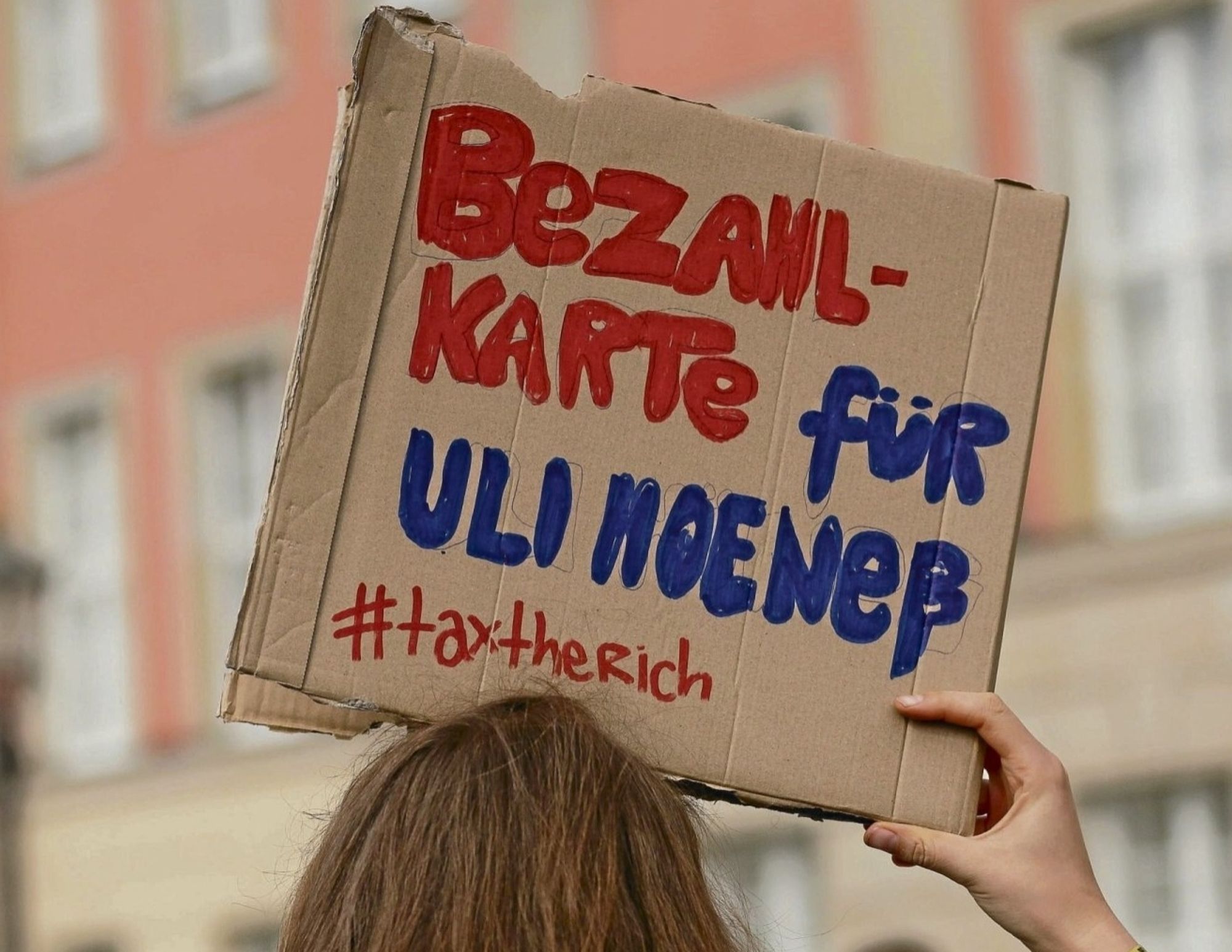 Bild eines Demoschildes aus dem steht in roter Schrift: BEZAHLKARTE und in Blau: für ULI HOENESS
darunter in rot: #taxtheRich