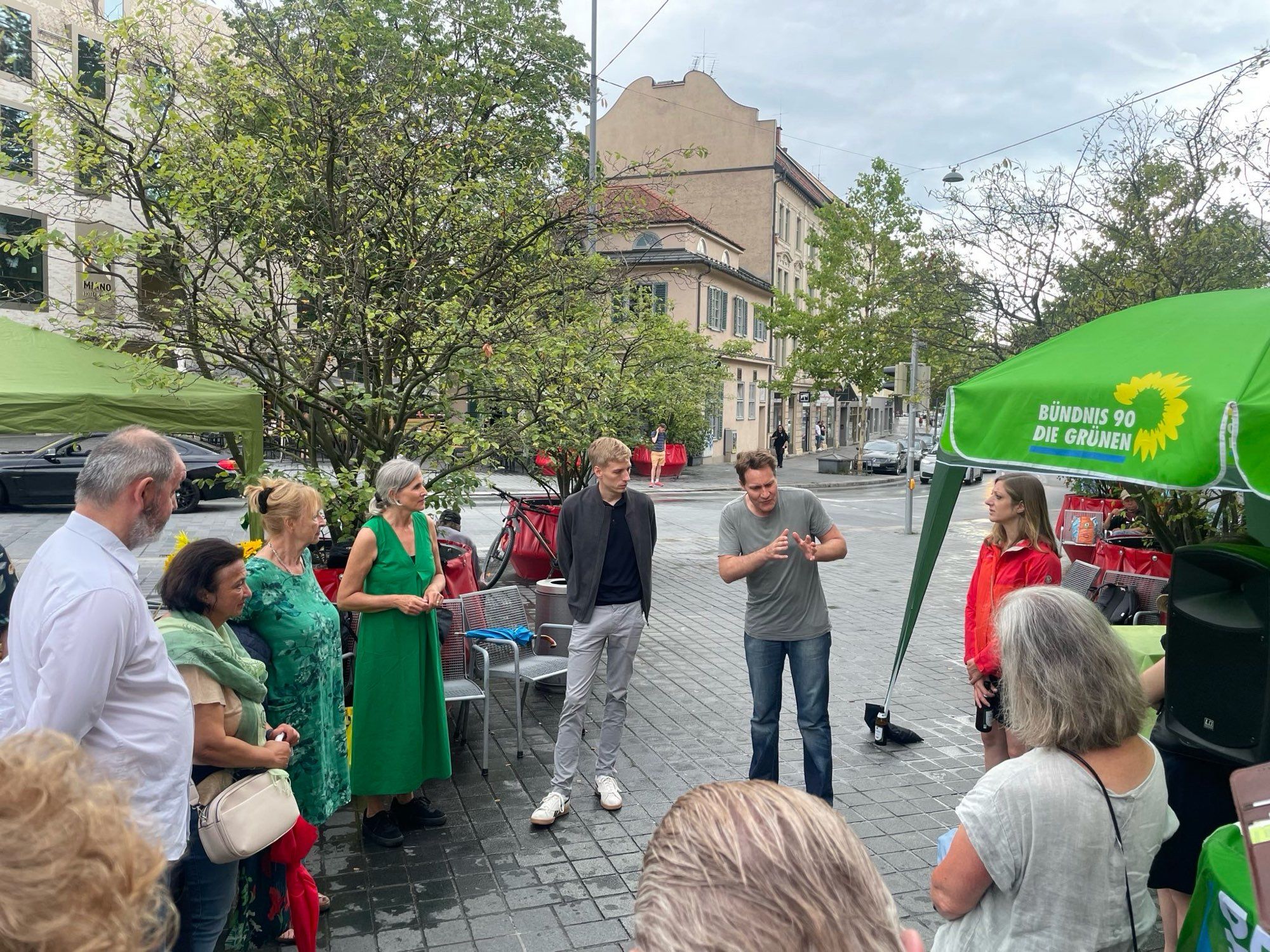 Judith Greif, Dominik Krause und Ludwig Hartmann von den Münchner Grünen im Gespräch mit Mitgliedern und Gäst*innen beim Green Dinner auf dem Pasinger Marienplatz.