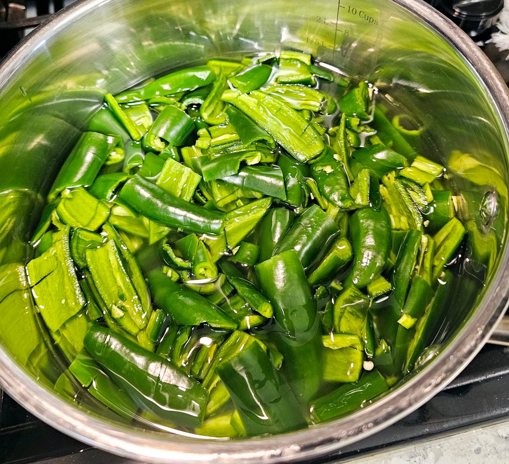 Boiling down jalapeños to make jelly.