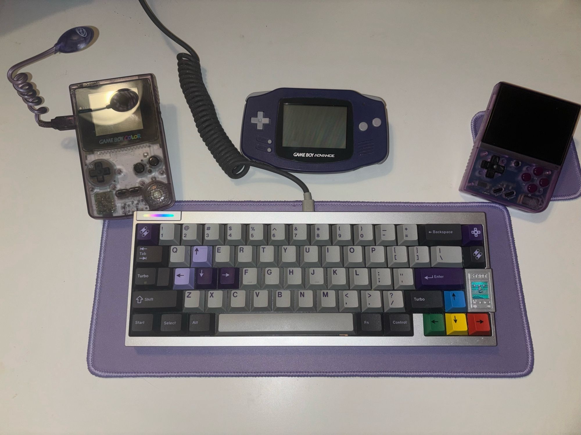 Purple game boy color, game boy advance, and Miyoo mini plus with a SNES themed keyboard