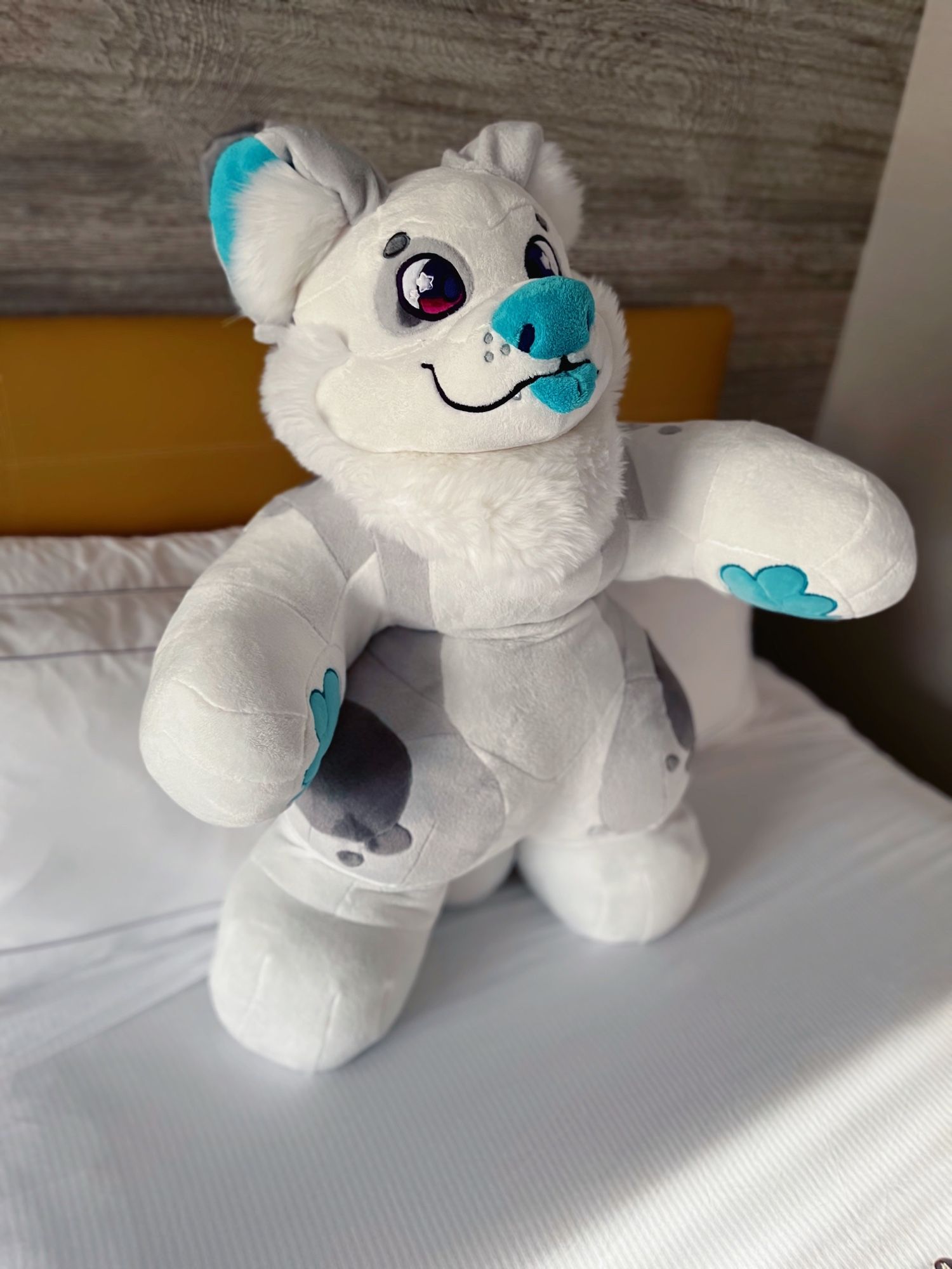 A white and gray plushie of an anthro dog with blue accents. Extremely adorable and chunky.