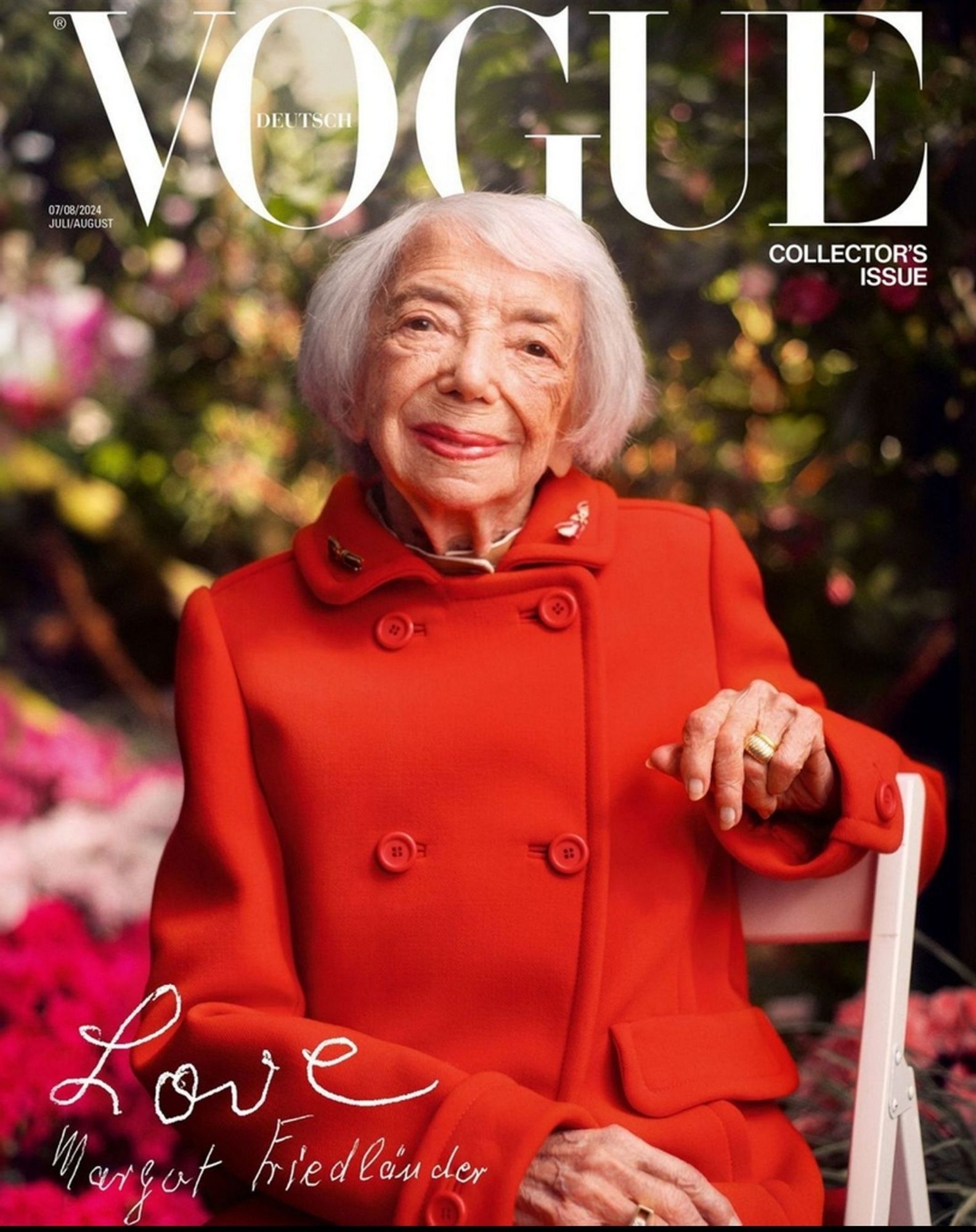 Abbildung des Covers der Vogue Deutsch, Collectors Issue, Ausgabe Juli/August 2024. "Cover Girl" ist Margot Friedländer, eine alte Dame, in knallig rotem Kostüm, auf einem Gartenstuhl sitzend vor pinken, üppig blühenden Büschen, sie guckt leise lächelnd zur Betrachter*in. Handschriftlich steht unten links "Love" und ihre Unterschrift