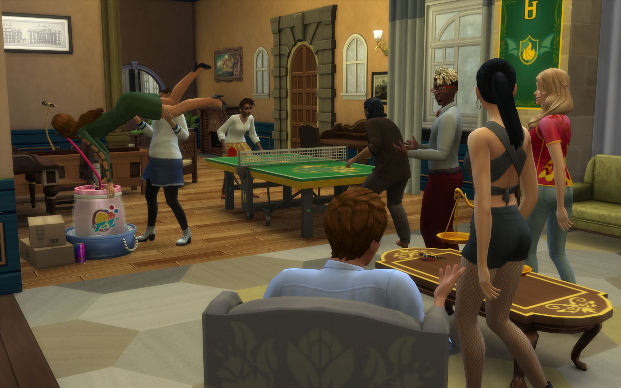 At Darby's Den in Britechester. Cameron, Jayden, Morgan, Julia, Becca, Grace, Tomax, and Jordan Mayer party together. Grace and Tomax play ping-pong. Cameron and Jayden talk with each other. Julia holds up Becca to drink from a keg. Cameron wears a grey shirt, red bow tie, and red trousers. Morgan wears a black cropped tank top, black hotpants, fishnet pantihose, and black heels. Becca wears a short green dress and black heels. The others wear more casual clothes.