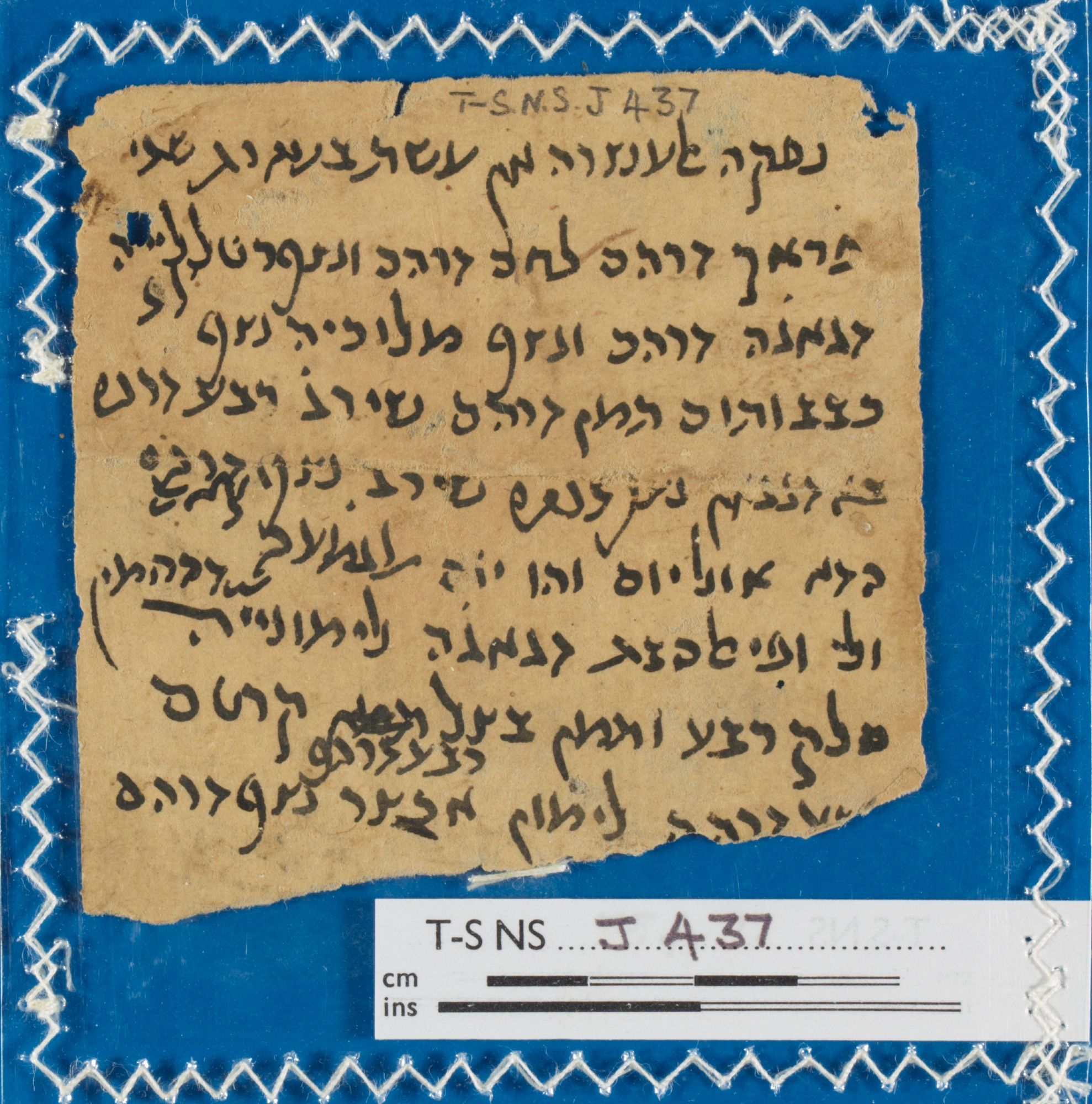 Torn, square-ish fragment of a light brown paper manuscript with 9 lines of Judaeo-Arabic text in black ink. Classmark is Cambridge University Library T-S NS J437.