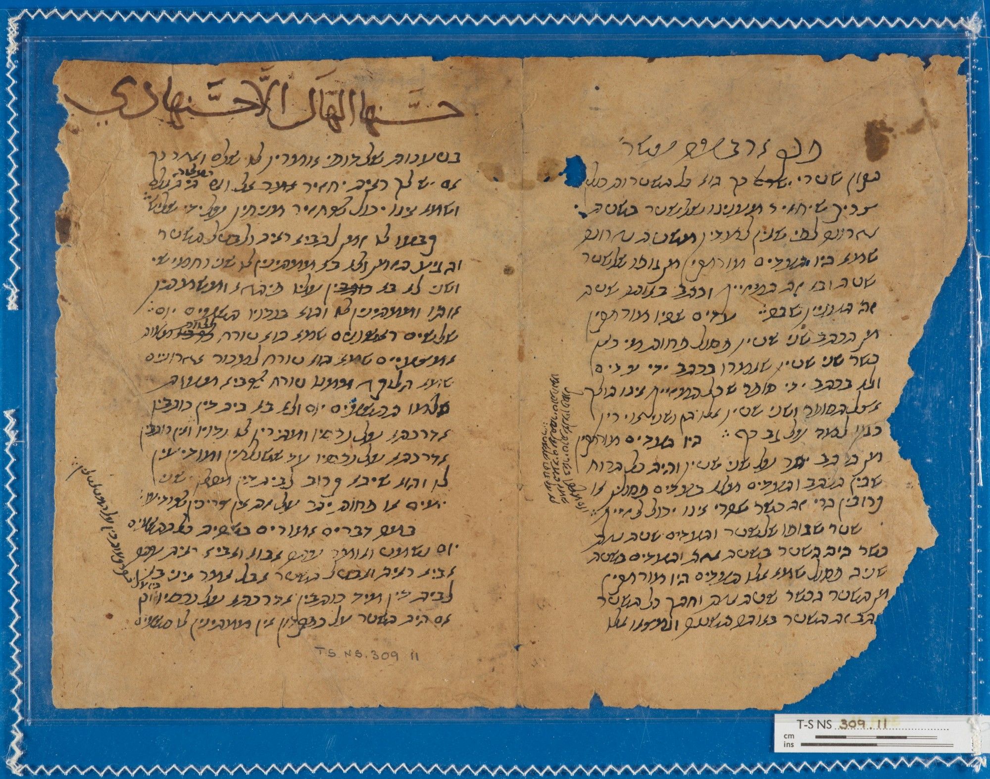 Light-coloured rag paper bifolium on a bright blue background. Messy Hebrew handwriting in brown-black ink covers both pages, including transverse writing in the margins. The righthand edge is torn and jagged. A large Arabic inscription in brown ink runs across the top of the lefthand page.