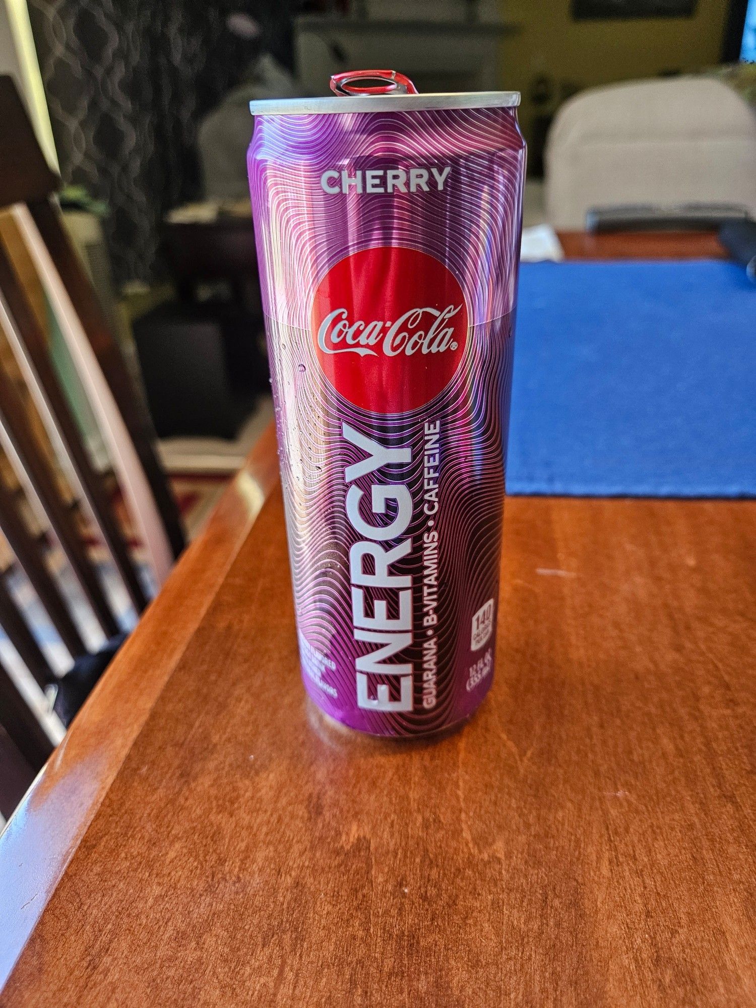 Can of Coke Energy drink (cherry flavor) sitting in a wooden kitchen table.