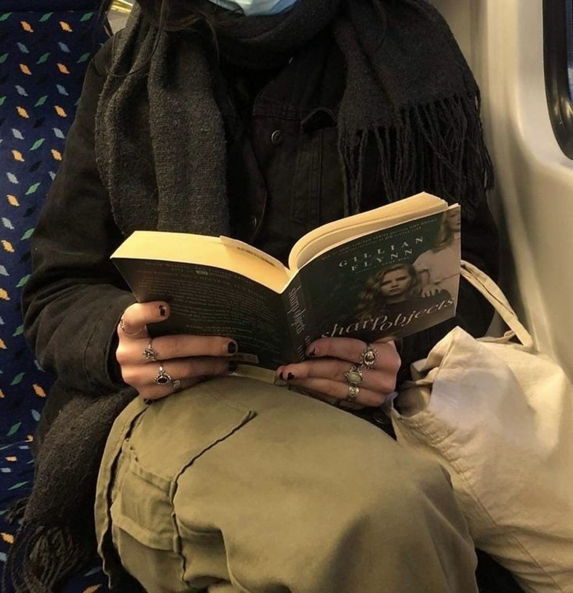 pessoa lendo um livro no metrô