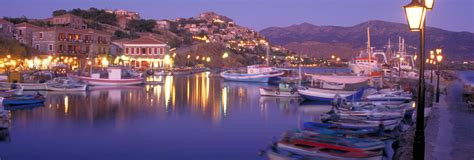 A classic small port scene with fishing boats and calm waters, at dawn or thereabouts from the island of Lesvos.