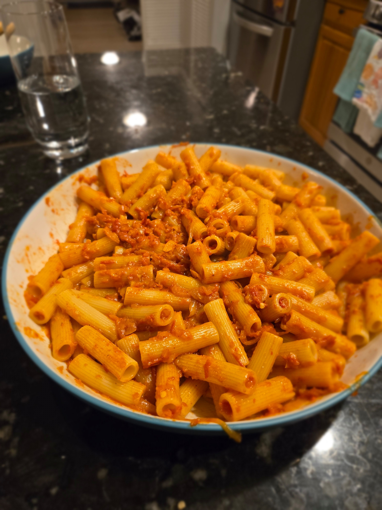 A bowl of rigatoni with a thicker tomato sauce tossed in it