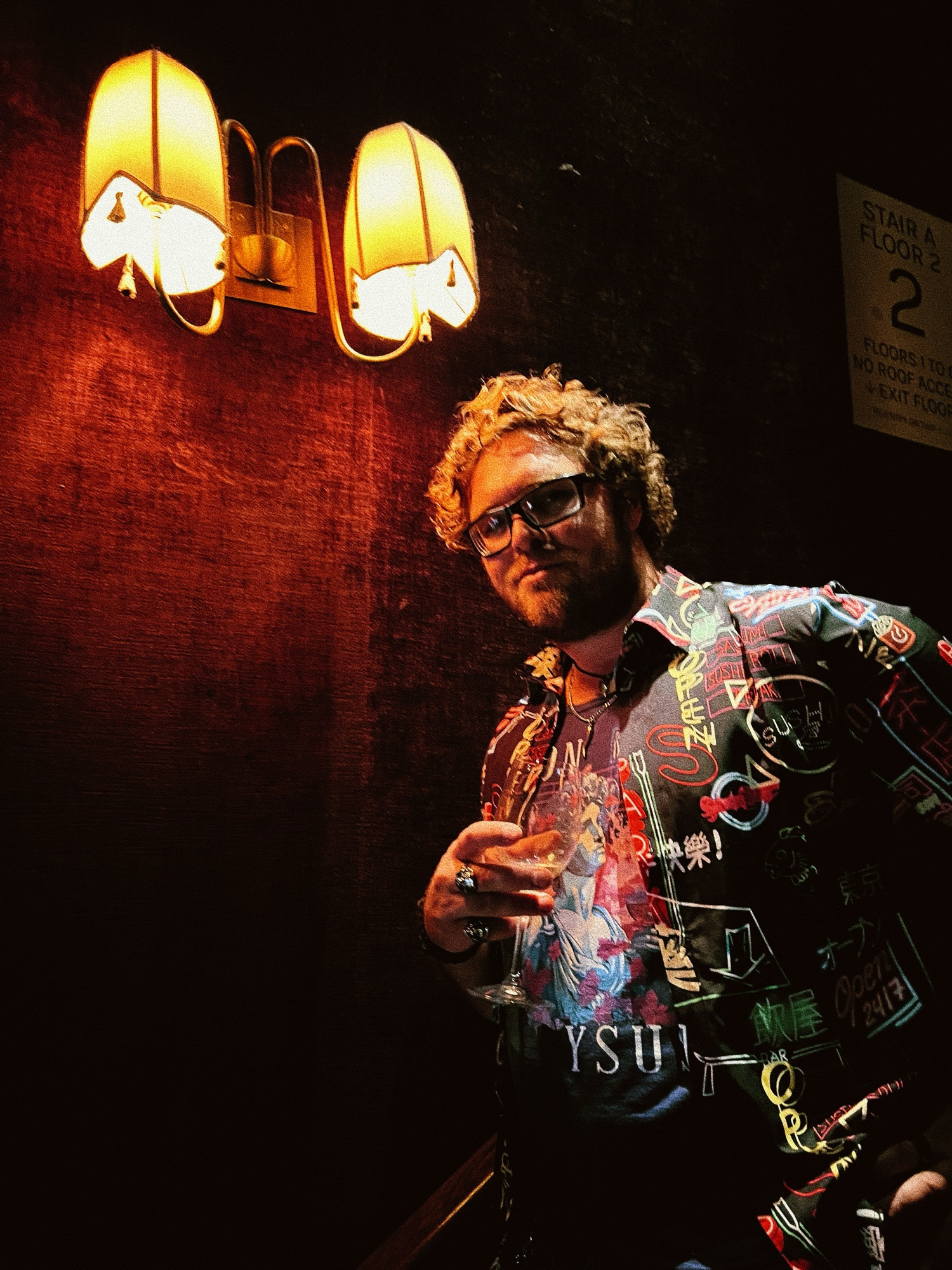 Man with a glass of wine posing for the camera with high contrast lighting