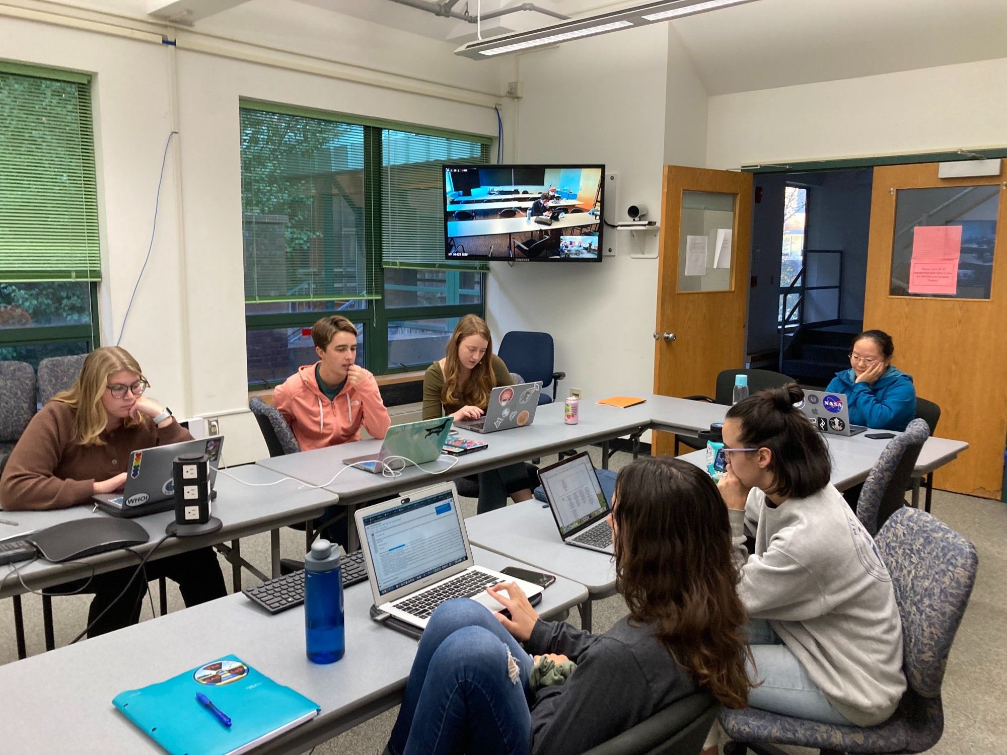 A group of students sit around tables in a classroom, preparing to take the ocean proteins CURE.