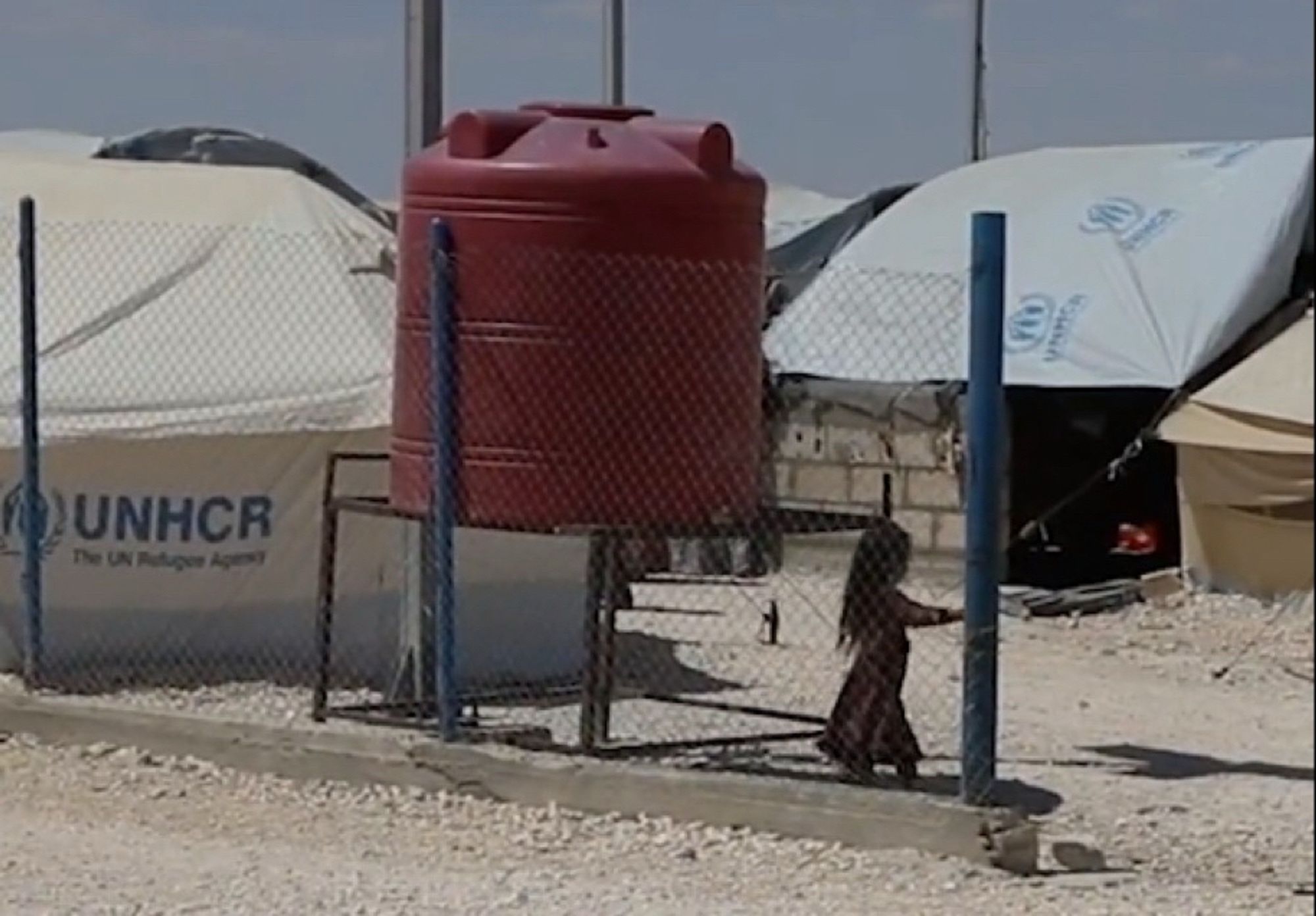 Une enfant au milieu d’un camp.