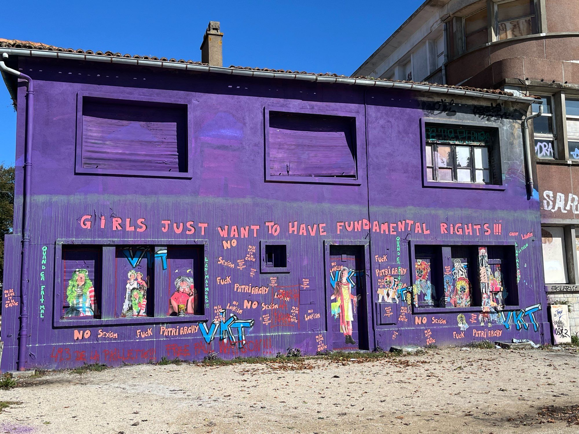 Maison peinte en violet avec des dessins et tags. Et surtout : Girls just want to have fundamental rights.