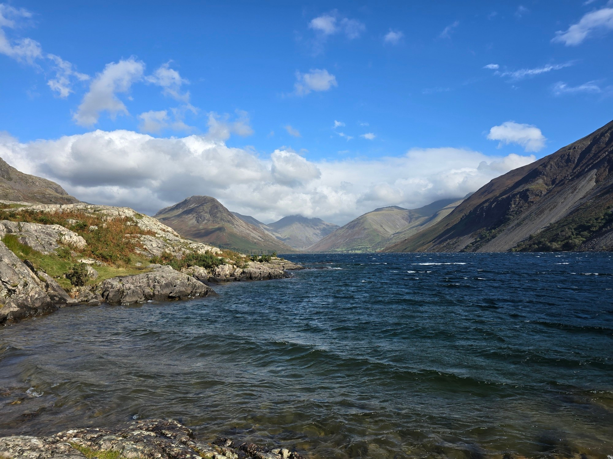 Wast Water in the Lake District. Lake in the foreground, mountains behind. Blue sky with clouds just above the mountains