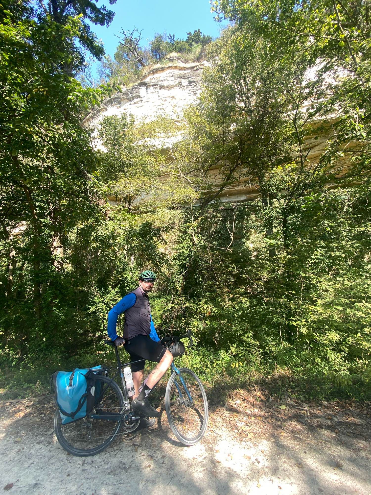 Dan stands with his bike near some limestone bluffs on the Katy Trail.