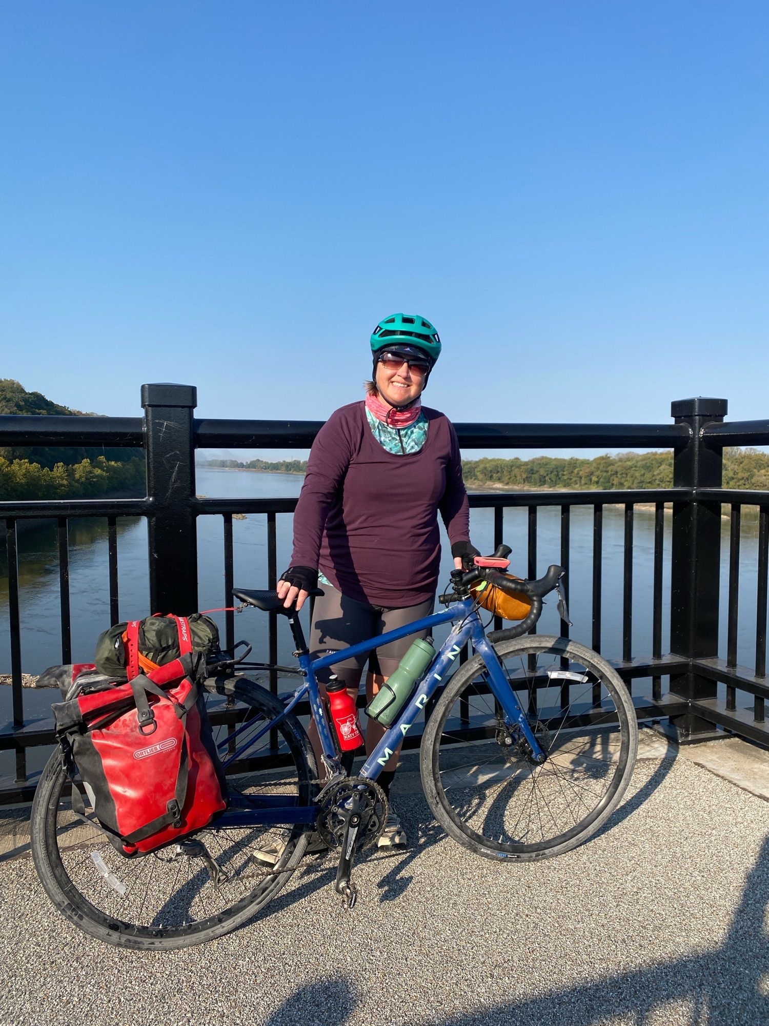 Carmen is standing with her bike on the bridge outside of Hermann, MO.