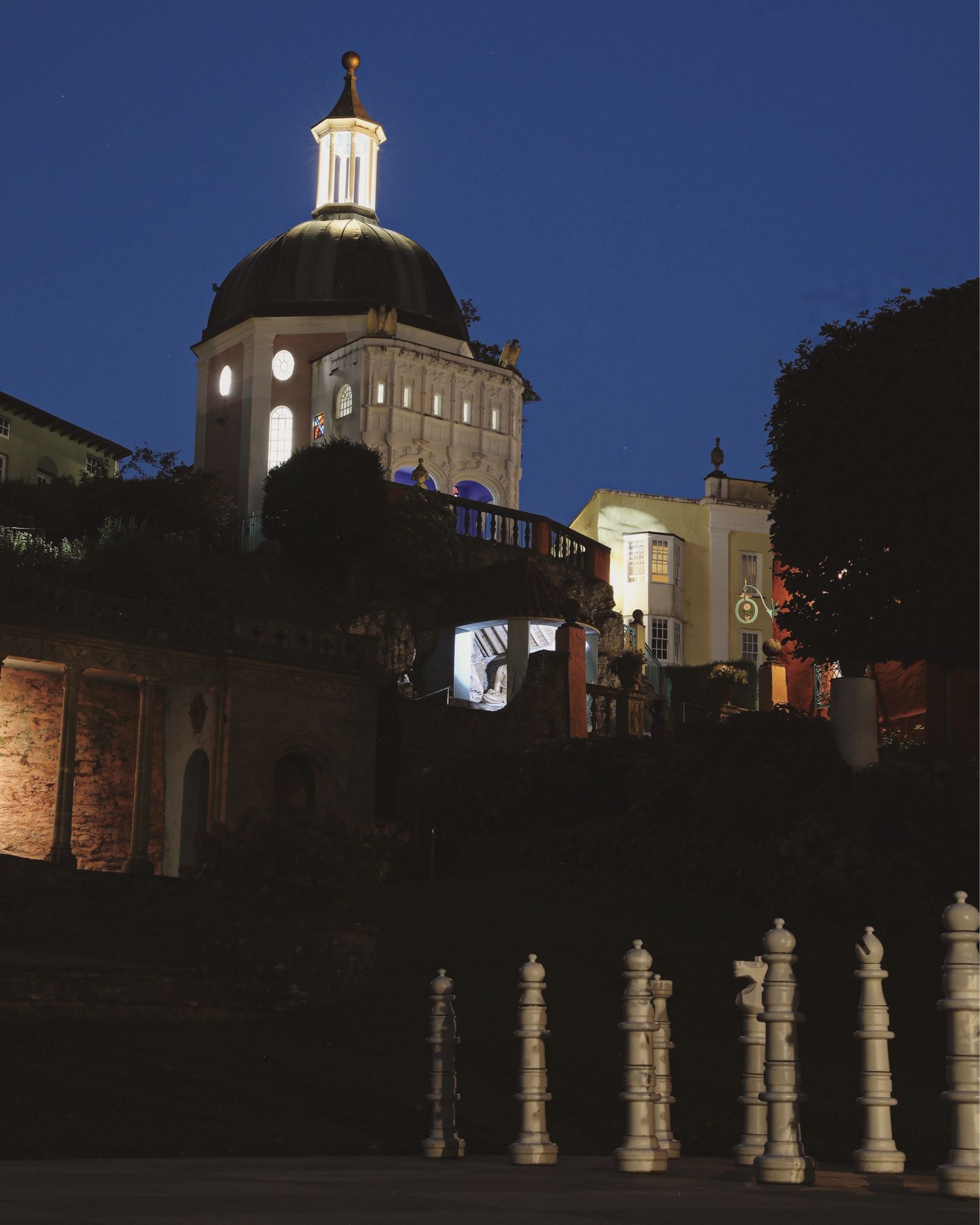 The Green Dome, Portmeirion, shot at night with the white pieces of The Village’s giant chess set standing in the foreground.