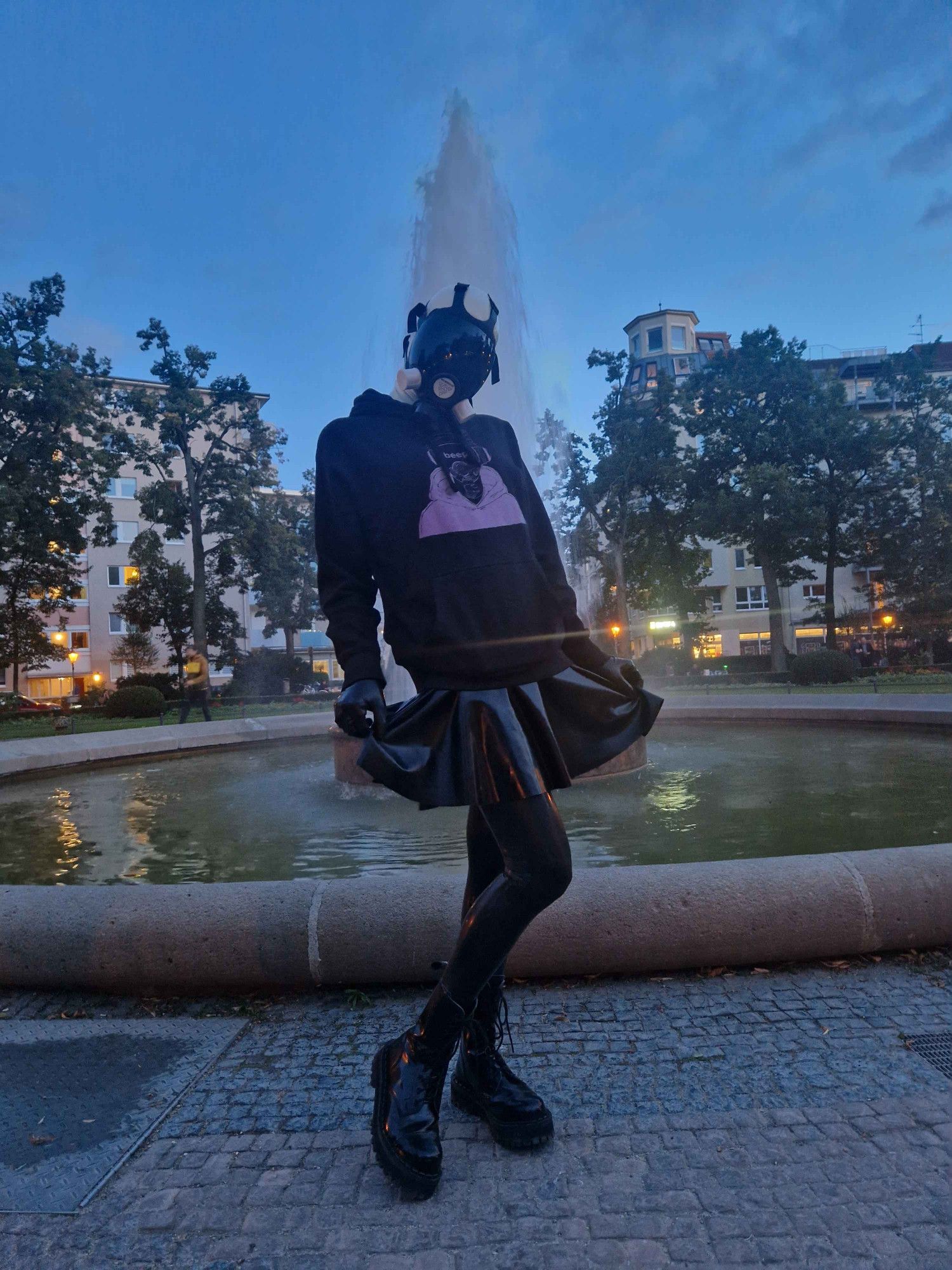 A full size shot, showing the latex clad legs, and the fountain spewing in the background