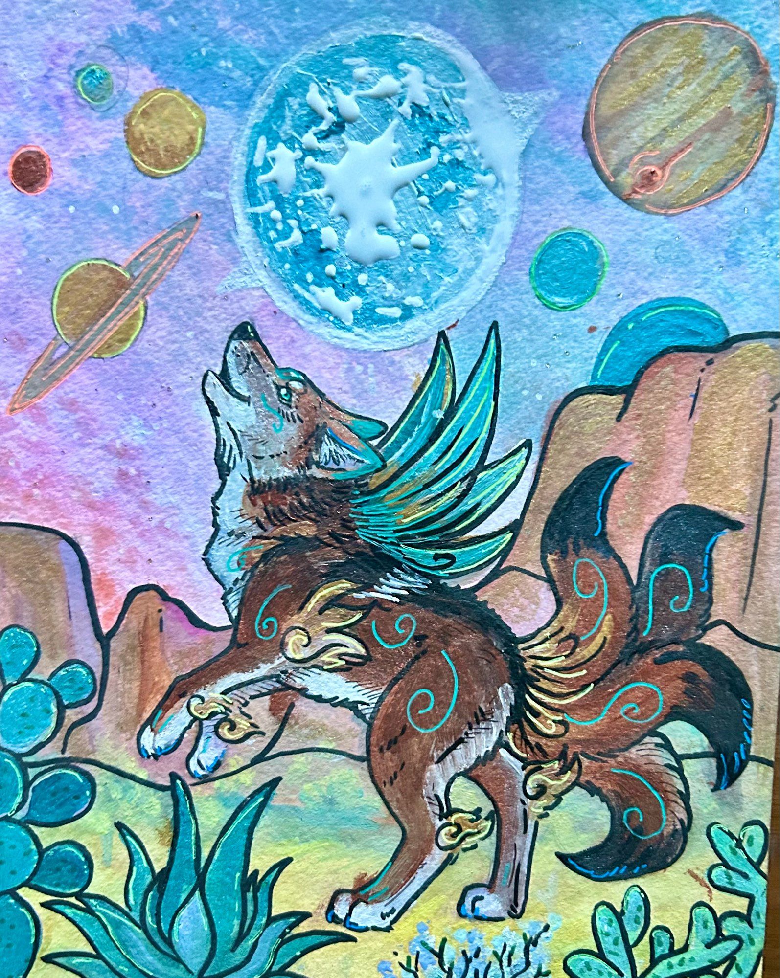 Watercolor and ink painting of a coyote standing on its hind legs and looking up. It has four tails, blue wings, and blue swirls on its fur. The background is a desert, with the sky full of planets and stars